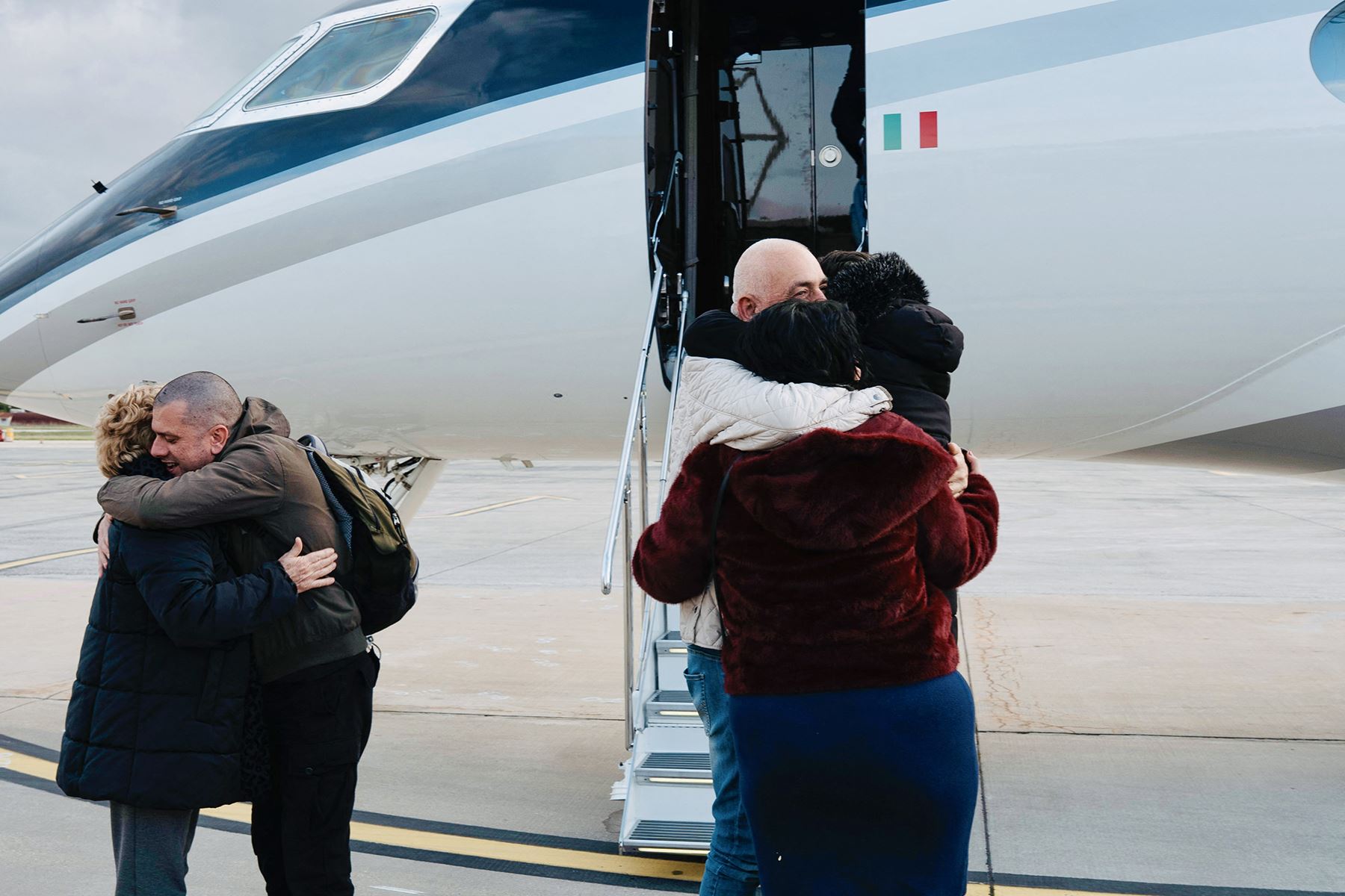 El trabajador humanitario italiano Alberto Trentini y el empresario italiano Mario Burlù son recibidos por sus familiares tras su liberación, a su llegada desde Venezuela al aeropuerto de Ciampino, en Roma. Foto: AFP
