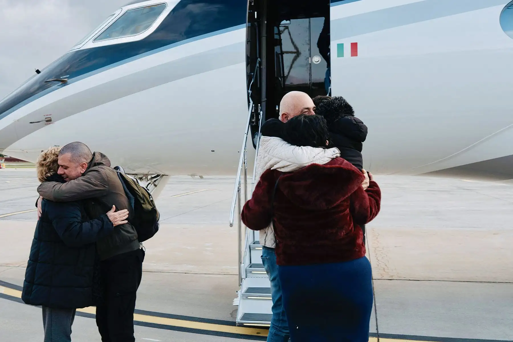 El trabajador humanitario italiano Alberto Trentini y el empresario italiano Mario Burlù son recibidos por sus familiares tras su liberación, a su llegada desde Venezuela al aeropuerto de Ciampino, en Roma. Foto: AFP