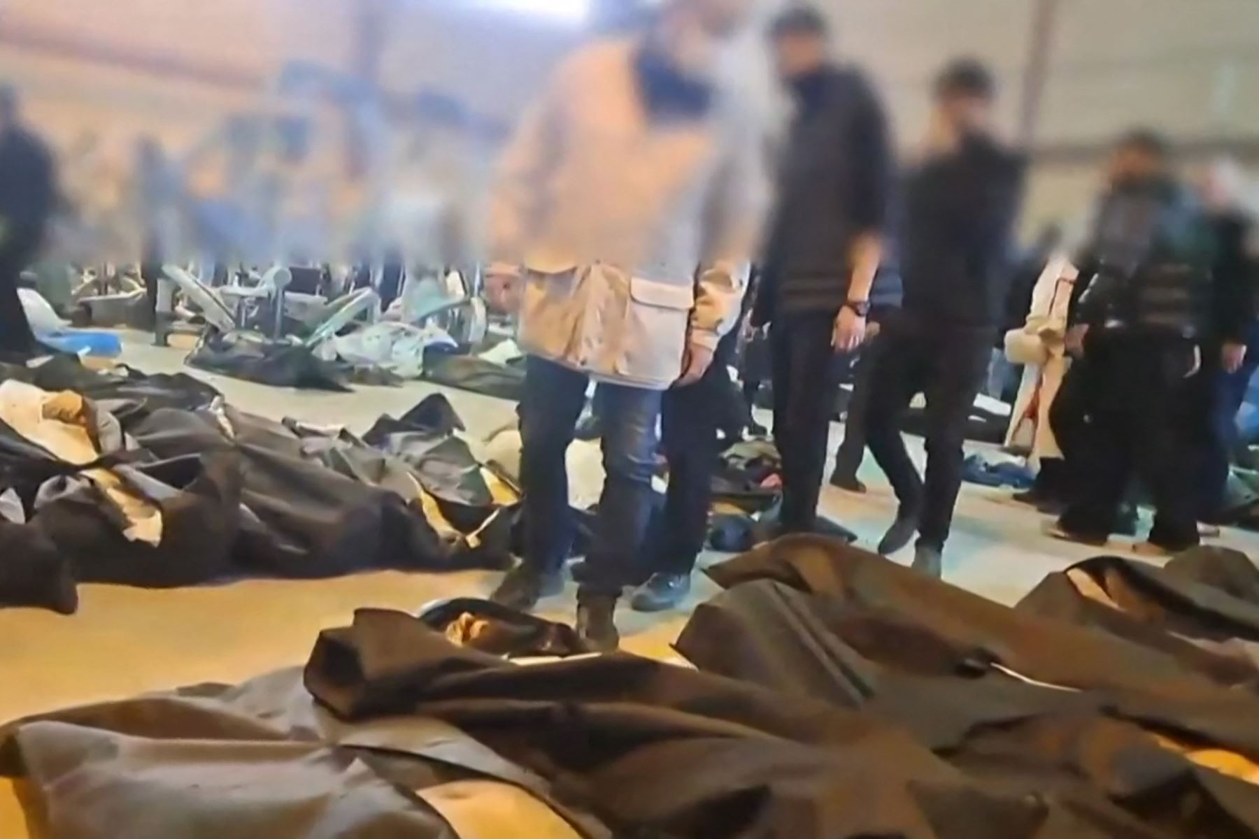 Esta captura de video muestra cuerpos sin vida en el Centro de Diagnóstico y Laboratorio Forense de Teherán, junto a quienes parecen ser familiares afligidos buscando a sus seres queridos. Imagen: AFP- SOURCE: ANONYMOUS.