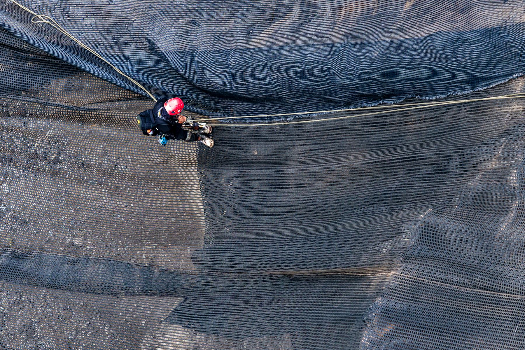 Las labores de reducción de riesgos abarcan una extensión aproximada de 30 000 mz que incluyen la instalación y mantenimiento de geomallas, con la finalidad de preservar la integridad estructural de los taludes y reducir el riesgo de desprendimiento de piedras y material suelto hacia la vía metropolitana.
 Foto: ANDINA/Ricardo Cuba