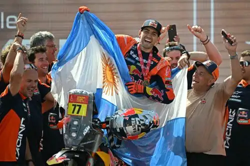 El piloto argentino Luciano Benavides con una Ktm 450 Rally Factory sostiene la bandera de su país mientras celebra en el podio tras ganar la 48ª edición del Rally Dakar 2026 en Yanbu, Arabia Saudita. Foto: AFP