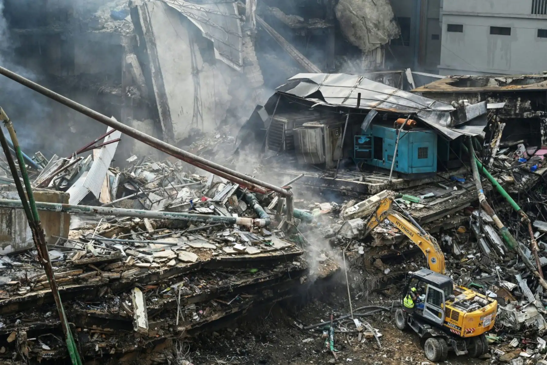 Los equipos de rescate buscan entre los escombros con excavadoras tras un gran incendio en un centro comercial de Karachi el 19 de enero de 2026. Foto: ANDINA/AFP