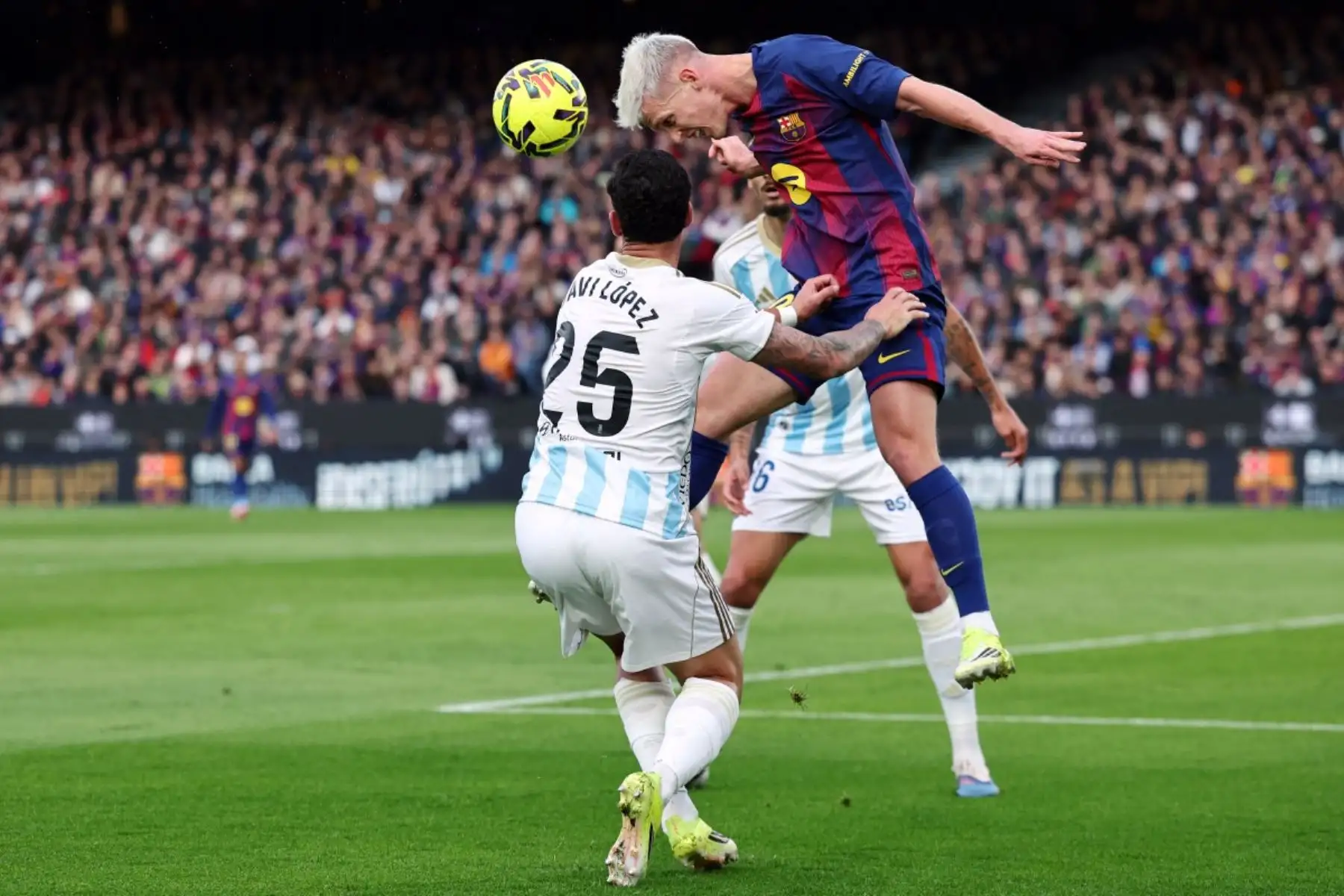 El centrocampista español del Barcelona #20 Daniel Olmo encabeza la pelota junto al defensor español del Real Oviedo #25 Javi López durante el partido de fútbol de la liga española entre el FC Barcelona y el Real Oviedo en el Estadio Camp Nou de Barcelona el 25 de enero de 2026. (Foto de Josep LAGO / AFP)