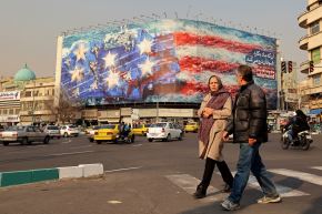 Peatones pasan junto a una valla publicitaria antiestadounidense instalada en la plaza Enqelab en Teherán, el 26 de enero de 2026. Foto: AFP