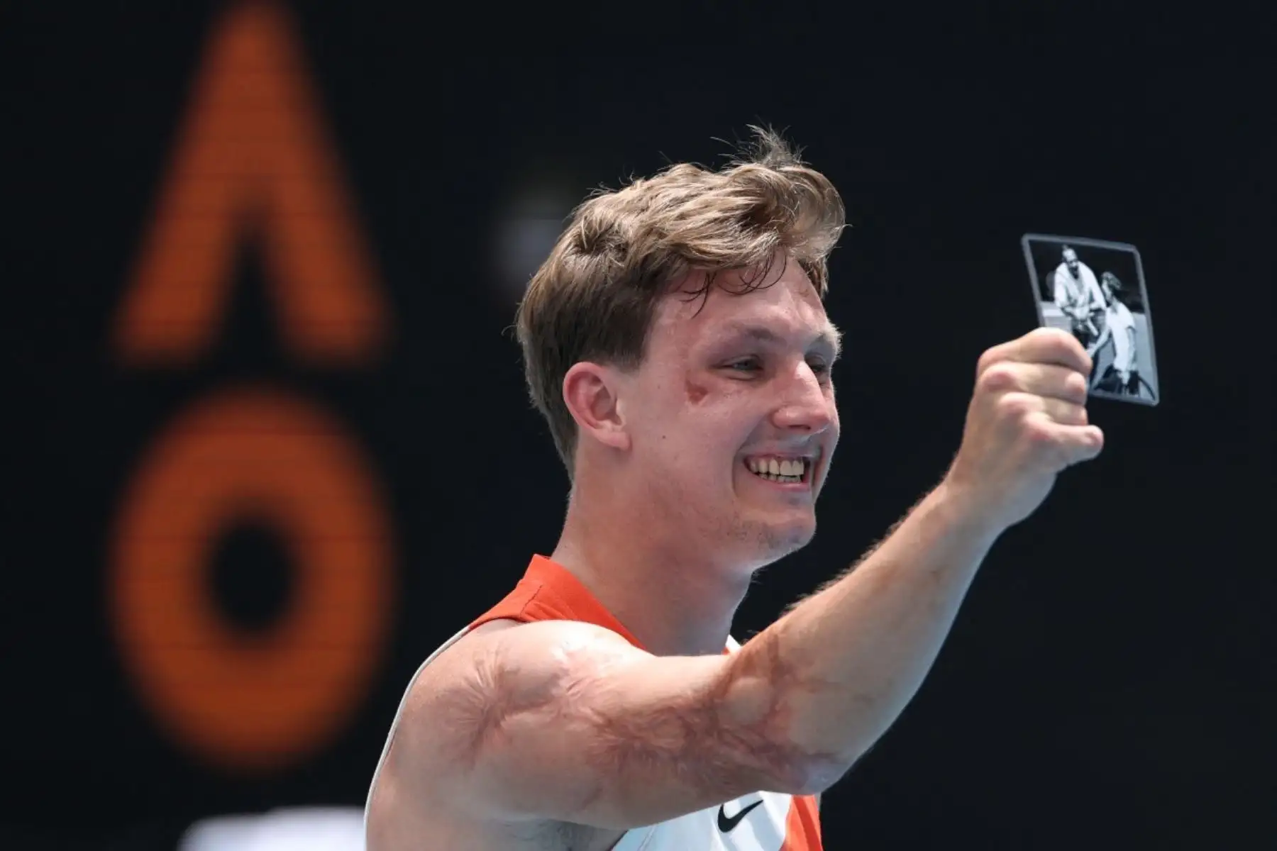 Niels Vink, de los Países Bajos, sostiene una foto de él con el difunto entrenador Hans Jurgen Striek mientras celebraba su victoria contra su compatriota Sam Schroder en su partido final en silla de ruedas cuádruple en el día catorce del torneo de tenis Abierto de Australia en Melbourne el 31 de enero de 2026. (Foto de Martin KEEP / AFP)