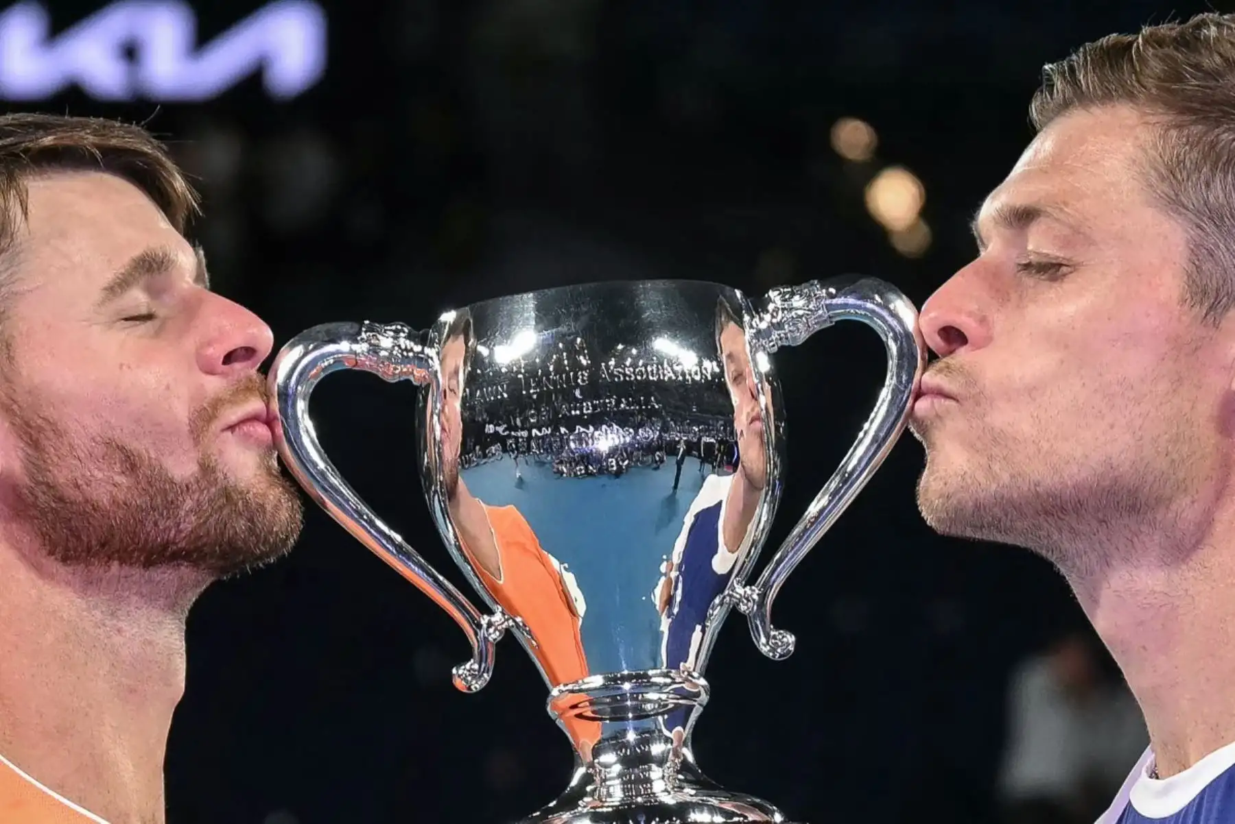 El británico Neal Skupski (R) y su compañero de EE. UU. Christian Harrison besan el trofeo ganador después de su victoria en el partido final de dobles masculinos contra Jason Kubler y Marc Polmans de Australia en el día catorce del torneo de tenis Abierto de Australia en Melbourne el 31 de enero de 2026. (Foto de WILLIAM WEST / AFP)