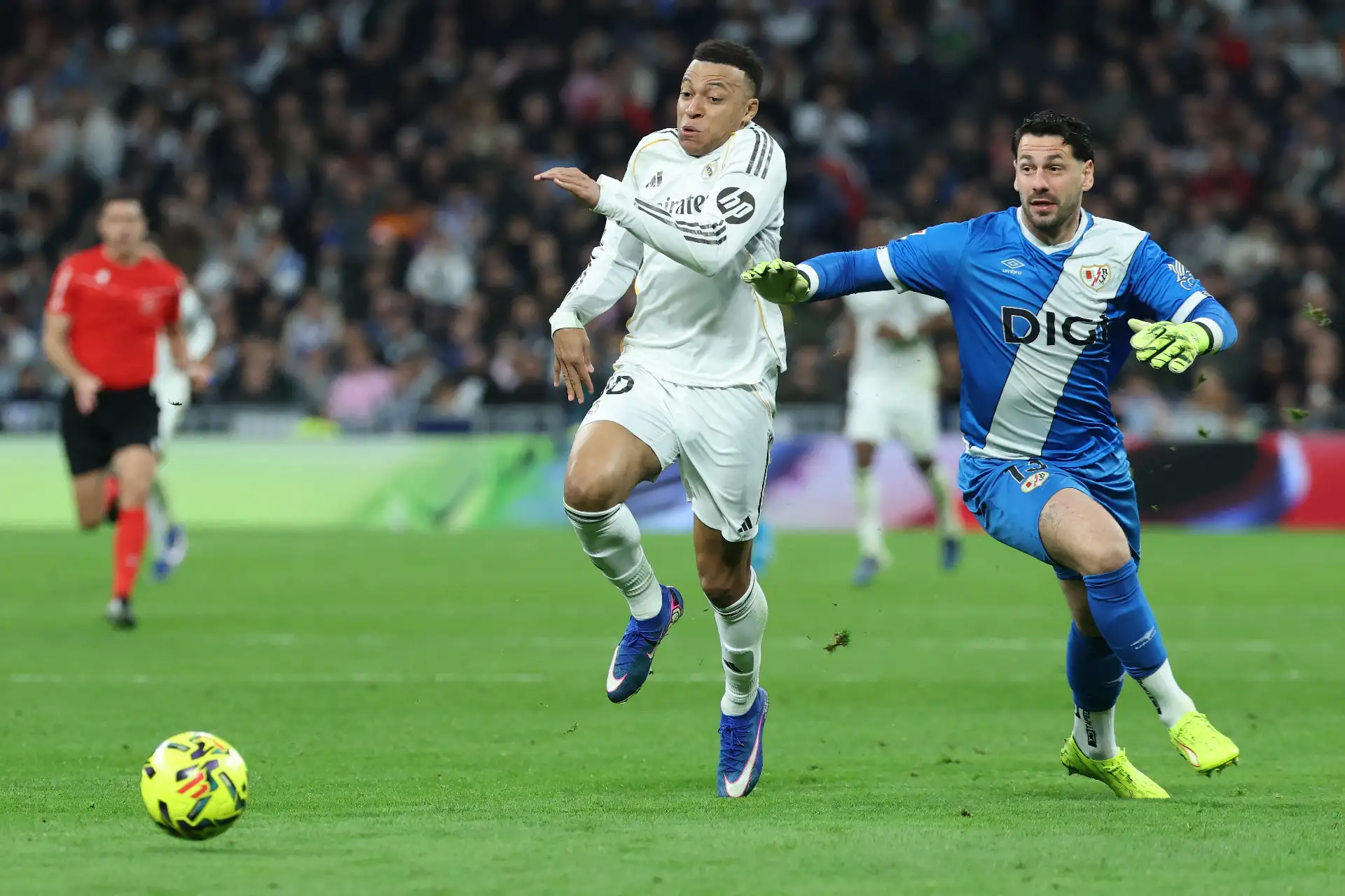 El delantero francés del Real Madrid, Kylian Mbappé, lucha por el balón con el portero argentino del Rayo Vallecano, Augusto Batalla, durante el partido de fútbol de la liga española entre el Real Madrid CF y el Rayo Vallecano en el estadio Santiago Bernabéu en Madrid.
Foto: AFP