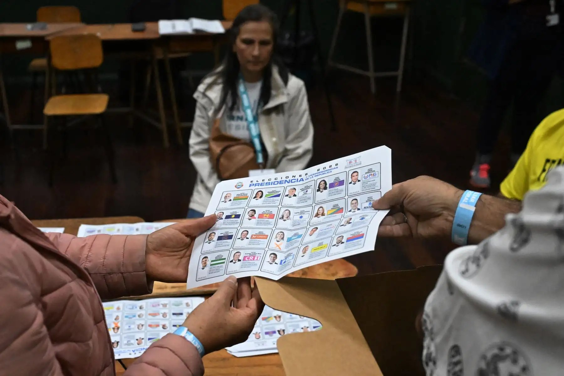 Funcionarios electorales muestran una papeleta mientras cuentan los votos tras el cierre de las urnas en el colegio electoral La Escuela Pilar Jiménez durante las elecciones presidenciales en San José.
Foto: AFP