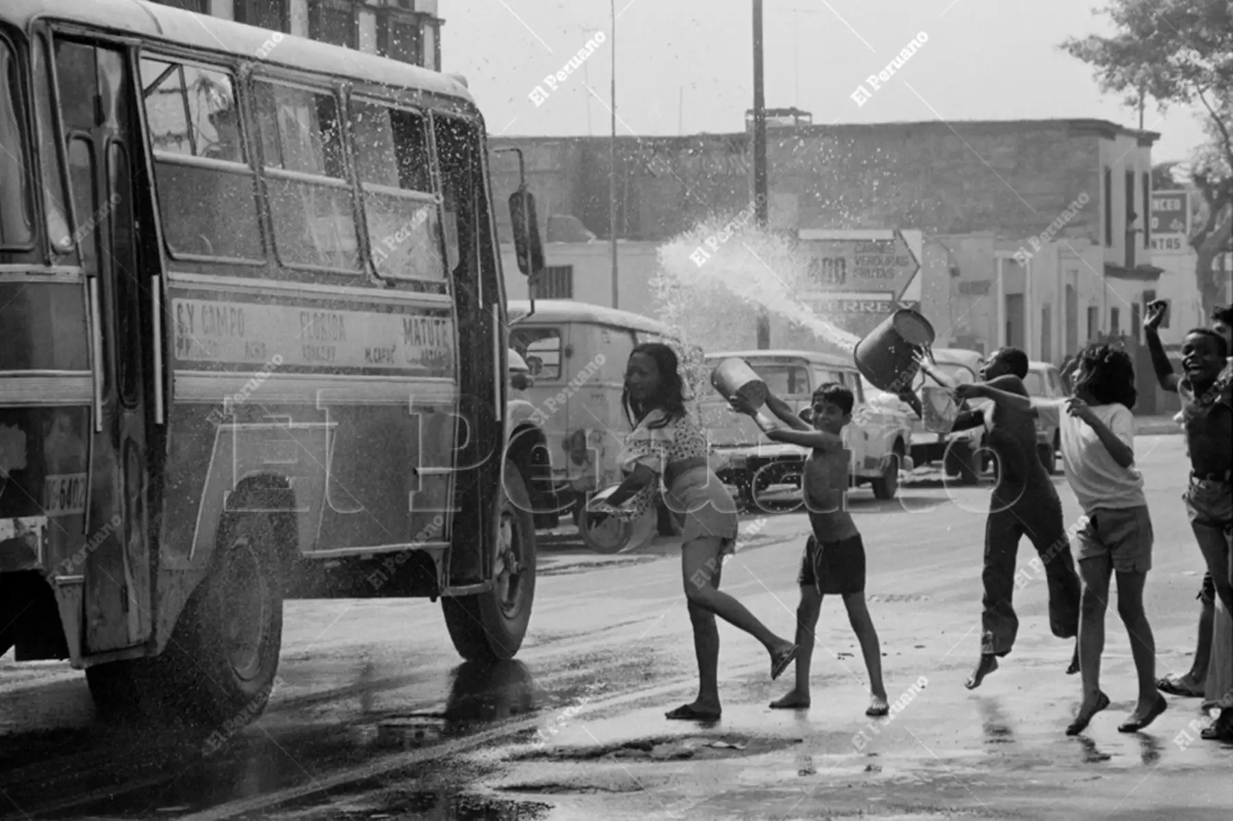 Lima - 12 febrero 1978 /  A baldazo limpio son recibidos los micros en una calle del Rímac. El agua corrió a raudales en el segundo domingo de carnaval.  Foto: Archivo Histórico de El Peruano / Norman Córdova
