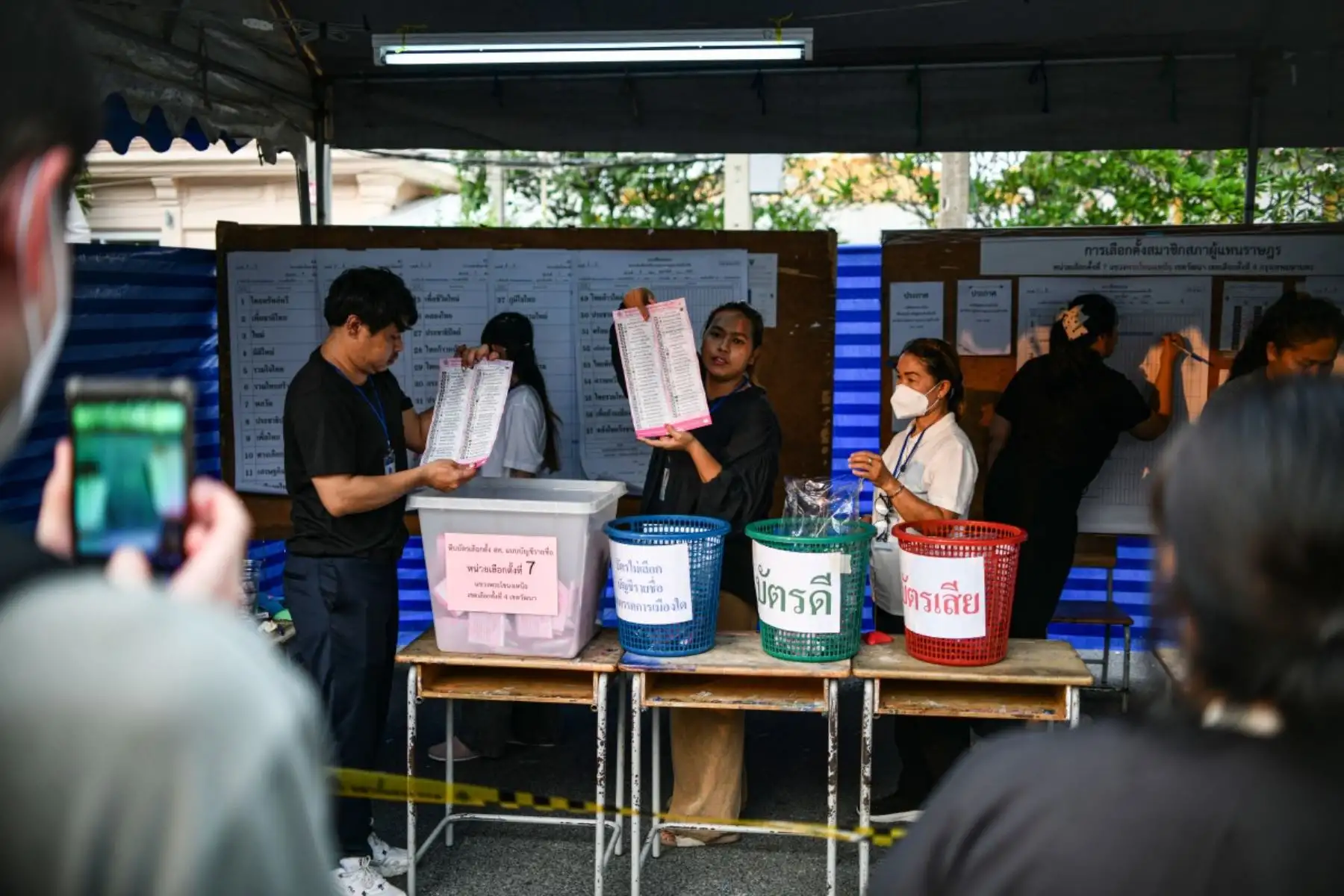 Personas observan el conteo de votos en las elecciones generales de Tailandia en un centro de votación de Bangkok. Foto: AFP