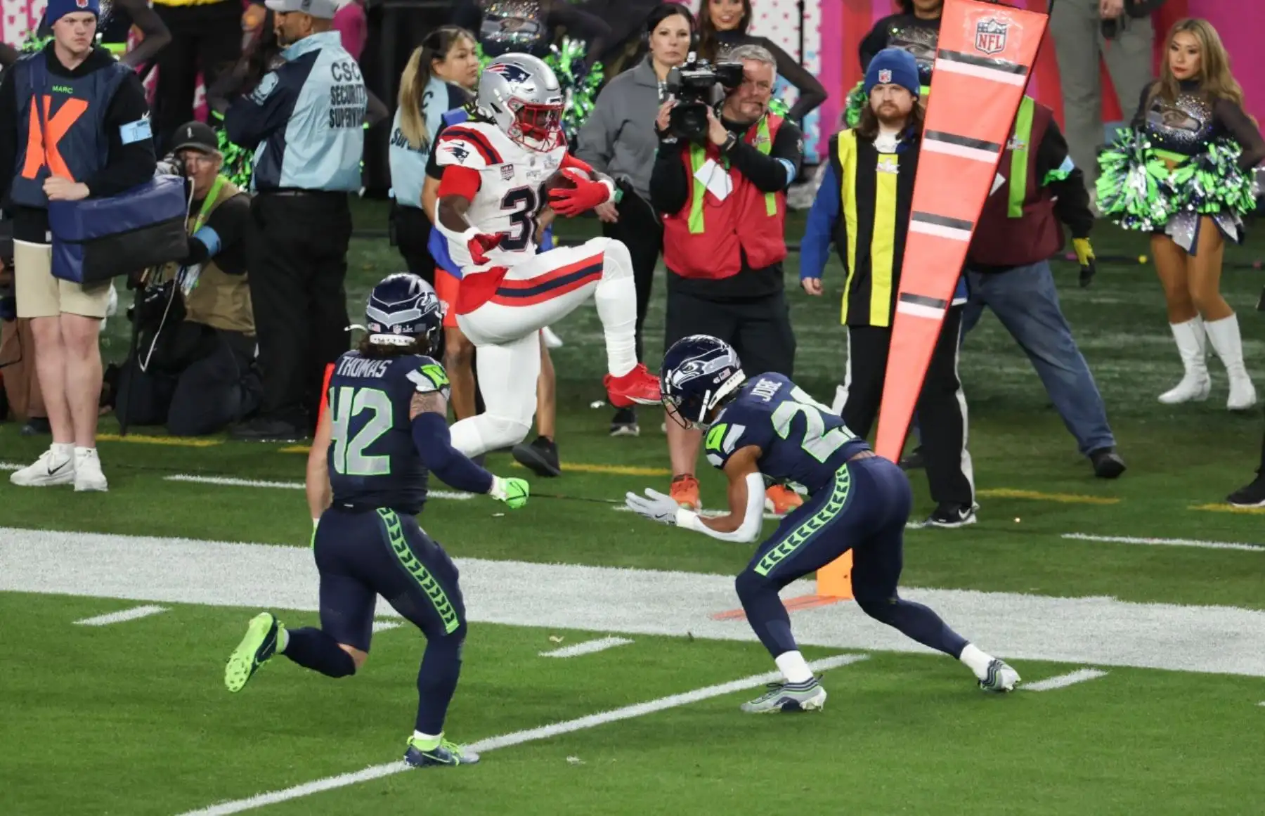 El corredor de los New England Patriots #38 Rhamondre Stevenson salta por encima de la línea de scrimmage durante la Super Bowl LX entre los New England Patriots y los Seattle Seahawks en el Levi