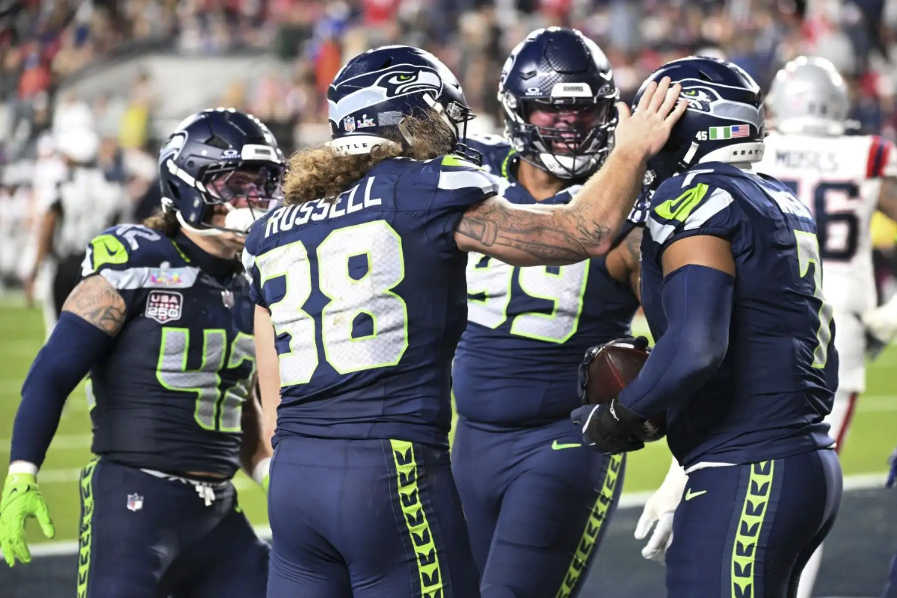 El linebacker #07 de los Seattle Seahawks, Uchenna Nwosu, celebra con sus compañeros tras anotar un touchdown durante el Super Bowl LX entre los New England Patriots y los Seattle Seahawks en el Levi