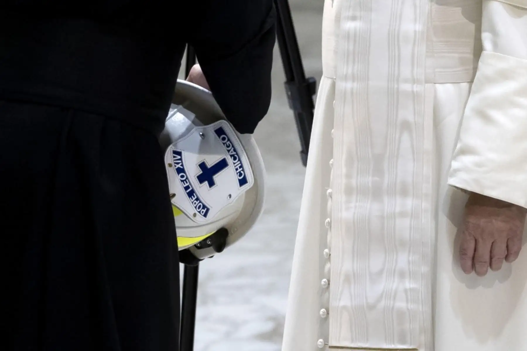 El capellán del Departamento de Bomberos de Chicago, Ryan Brady, saluda al papa León XIV  al obsequiarle un casco de bombero con el nombre del pontífice, durante la audiencia general semanal en el Aula Pablo VI, en la Ciudad del Vaticano. Foto: AFP