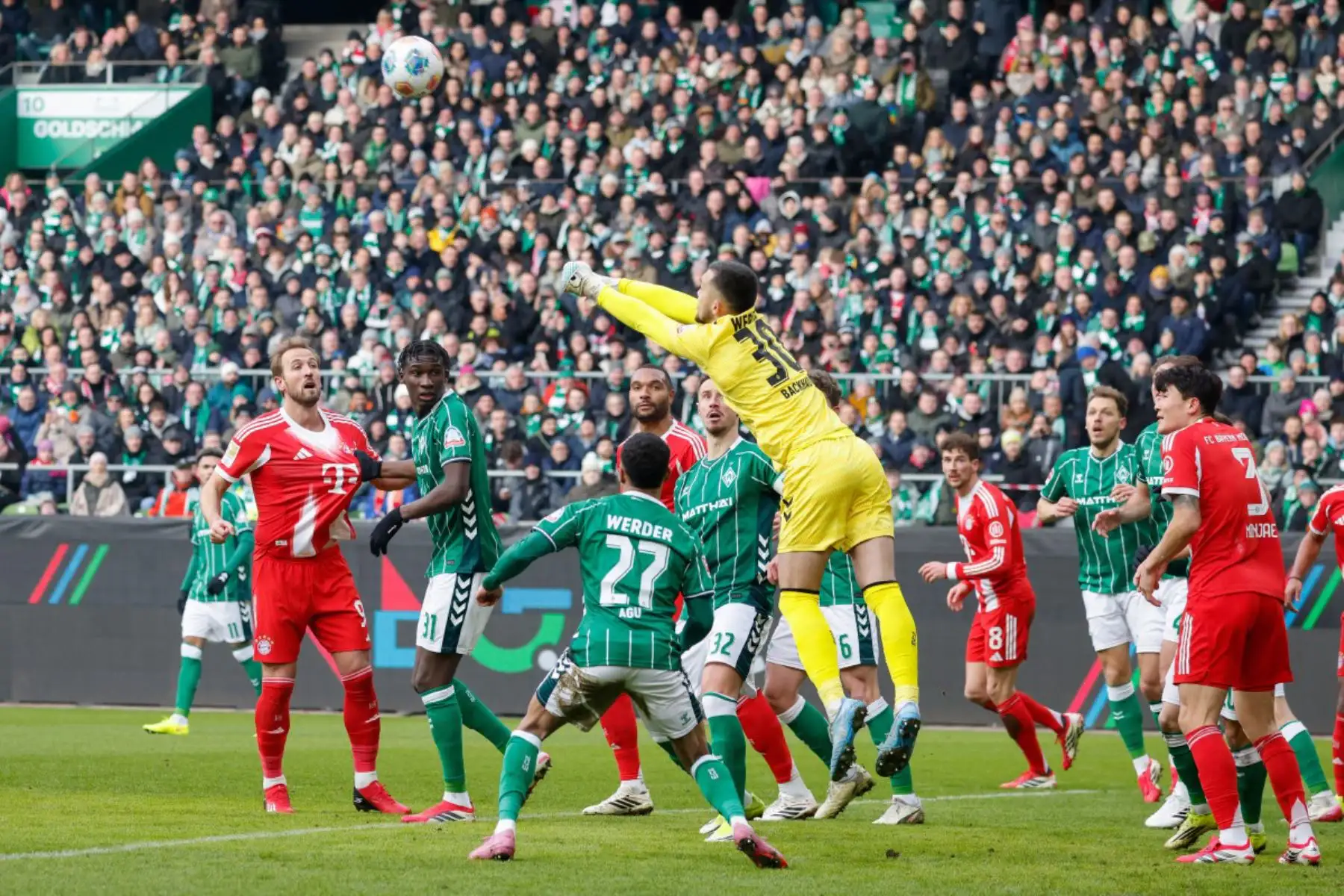 Los jugadores, incluido el delantero inglés 09 del Bayern Munich, Harry Kane, observan cómo el portero alemán 30 del Bremen, Mio Backhaus, despeja el balón con los puños durante el partido de fútbol de la primera división alemana, la Bundesliga, entre el SV Werder Bremen y el FC Bayern Munich en Bremen. Foto: ANDINA/ AFP