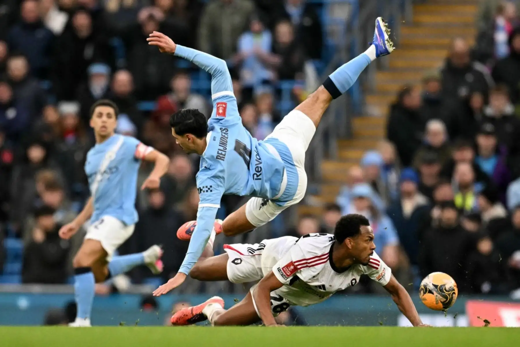 Español El defensa inglés 28 del Salford City, Zach Awe, tacklea al mediocampista holandés 04 del Manchester City, Tijjani Reijnders, durante el partido de tercera ronda de la FA Cup inglesa entre el Manchester City y el Salford City en el Etihad Stadium en Manchester, noroeste de Inglaterra. Foto: ANDINA/AFP