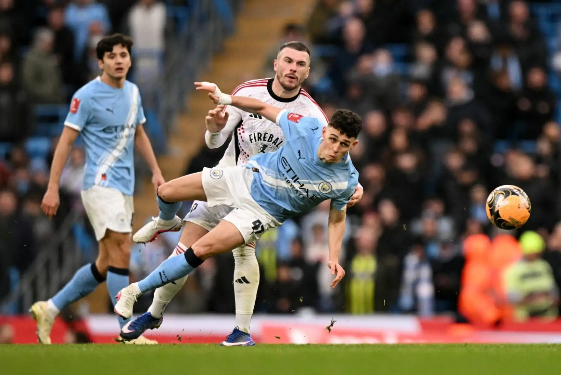 Español El centrocampista inglés del Manchester City 47 Phil Foden lucha por el balón con el delantero irlandés  26 del Salford City Ryan Graydon durante el partido de fútbol de tercera ronda de la Copa FA inglesa entre el Manchester City y el Salford City en el Etihad Stadium en Manchester, noroeste de Inglaterra. Foto: ANDINA/AFP