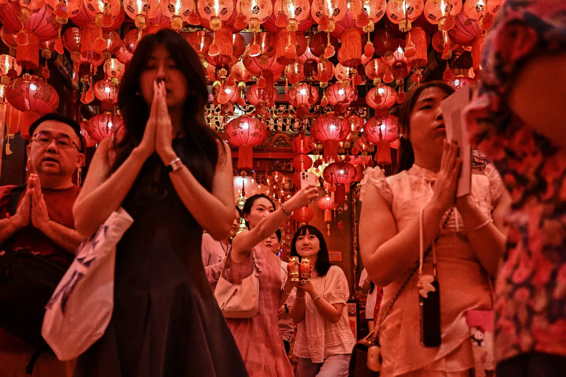Personas rezan en el templo Wat Mangkon Kamalawat en vísperas del Año Nuevo Lunar, en Bangkok.
Foto: AFP