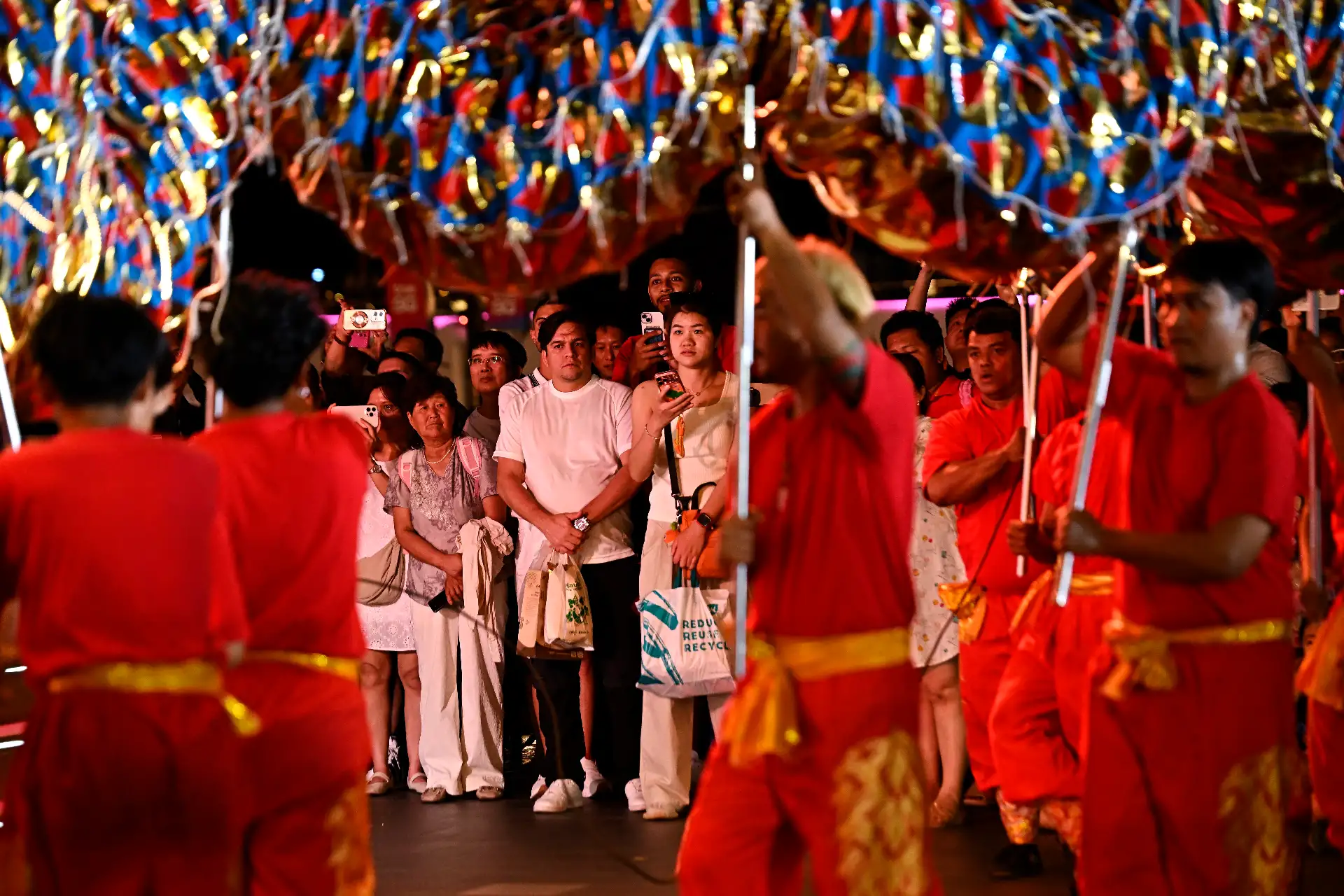 La gente observa a los bailarines de dragones actuar en el centro comercial Icon Siam en vísperas del Año Nuevo Lunar, en Bangkok.
Foto: AFP