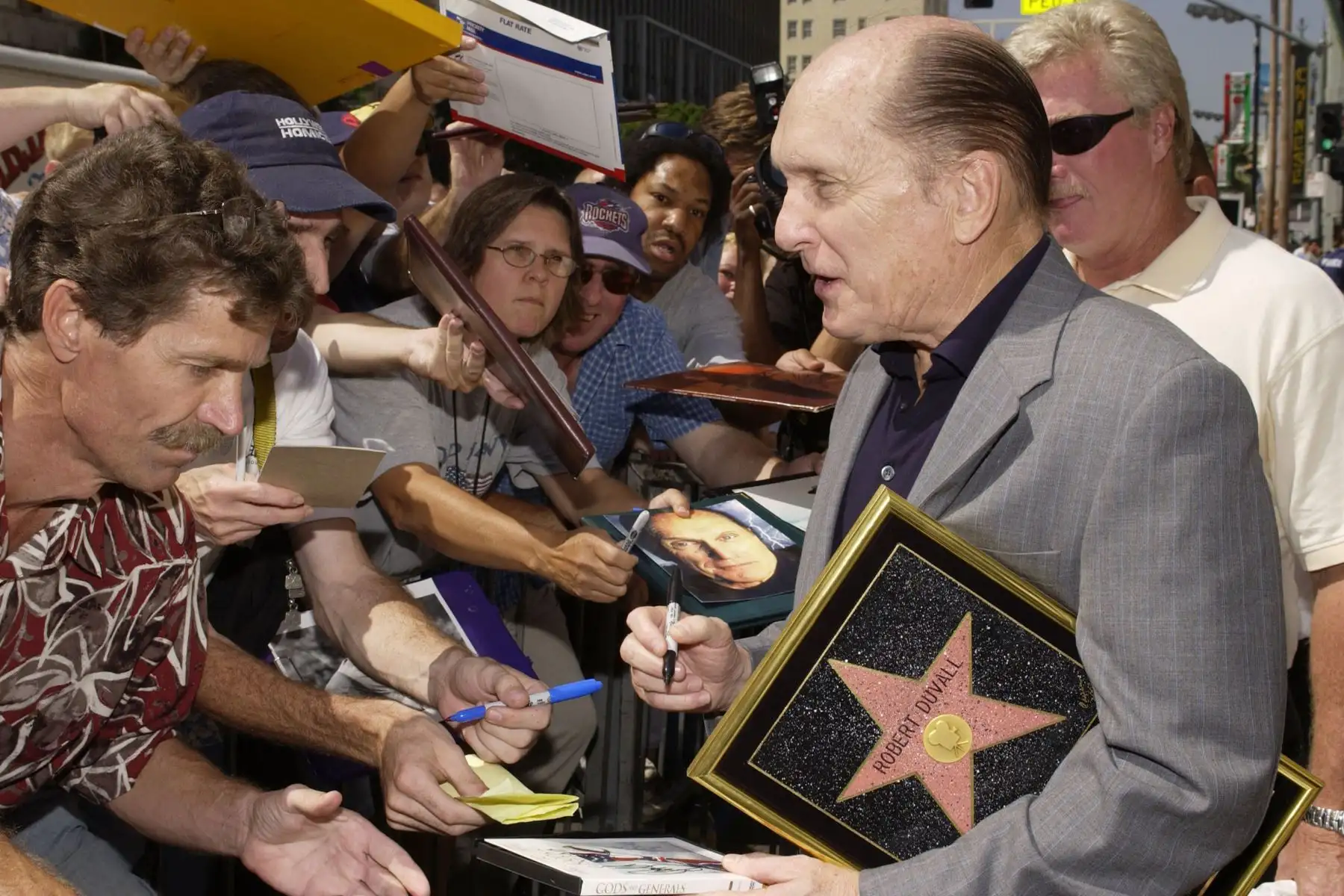 El actor Robert Duvall firma autógrafos tras la ceremonia en la que se le concedió una estrella en el Paseo de la Fama de Hollywood el 18 de septiembre de 2003 en Hollywood, California. 
Foto: AFP