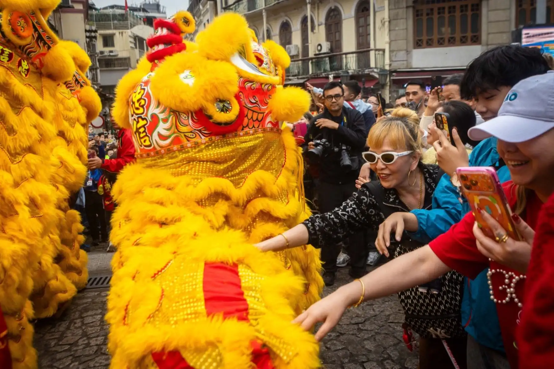 La gente toca al dragón para tener buena suerte frente a las ruinas de San Pablo durante las celebraciones del primer día del Año Nuevo Lunar del Caballo en Macao. Foto: AFP