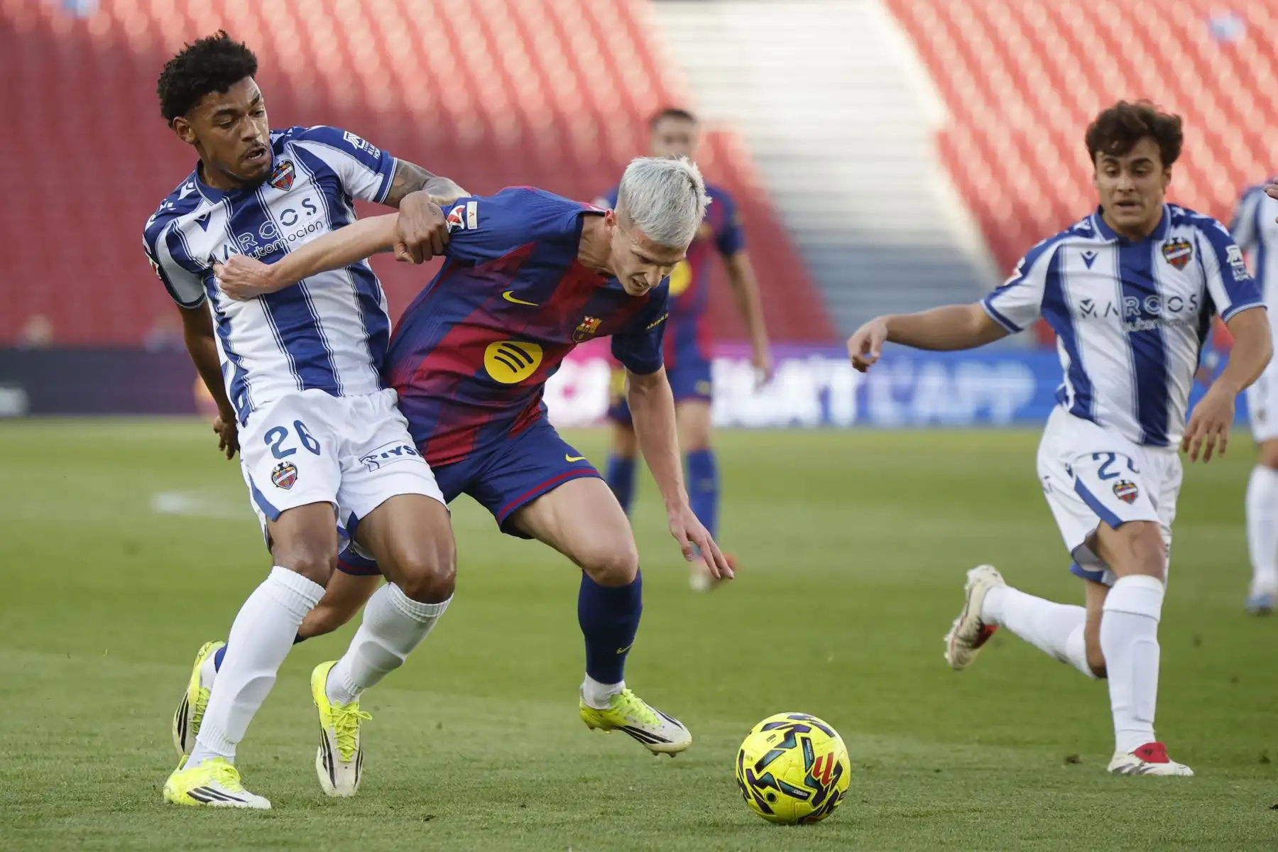 El centrocampista del FC Barcelona Dani Olmo disputa un balón con el delantero del Levante Kareem Tunde durante el partido de la jornada 25 de LaLiga EA Sports que FC Barcelona y el Levante UD disputan este domingo en el Spotify Camp Nou de Barcelona. ANDINA/EFE