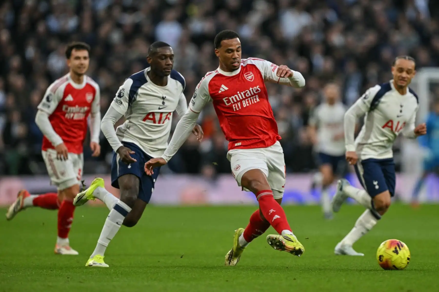 El delantero francés del Tottenham Hotspur Randal Kolo Muani desafía al defensa brasileño del Arsenal Gabriel Magalhaes  mientras pasa el balón durante el partido de la Premier League inglesa entre el Tottenham Hotspur y el Arsenal en el Tottenham Hotspur Stadium en Londres. Foto: ANDINA/AFP