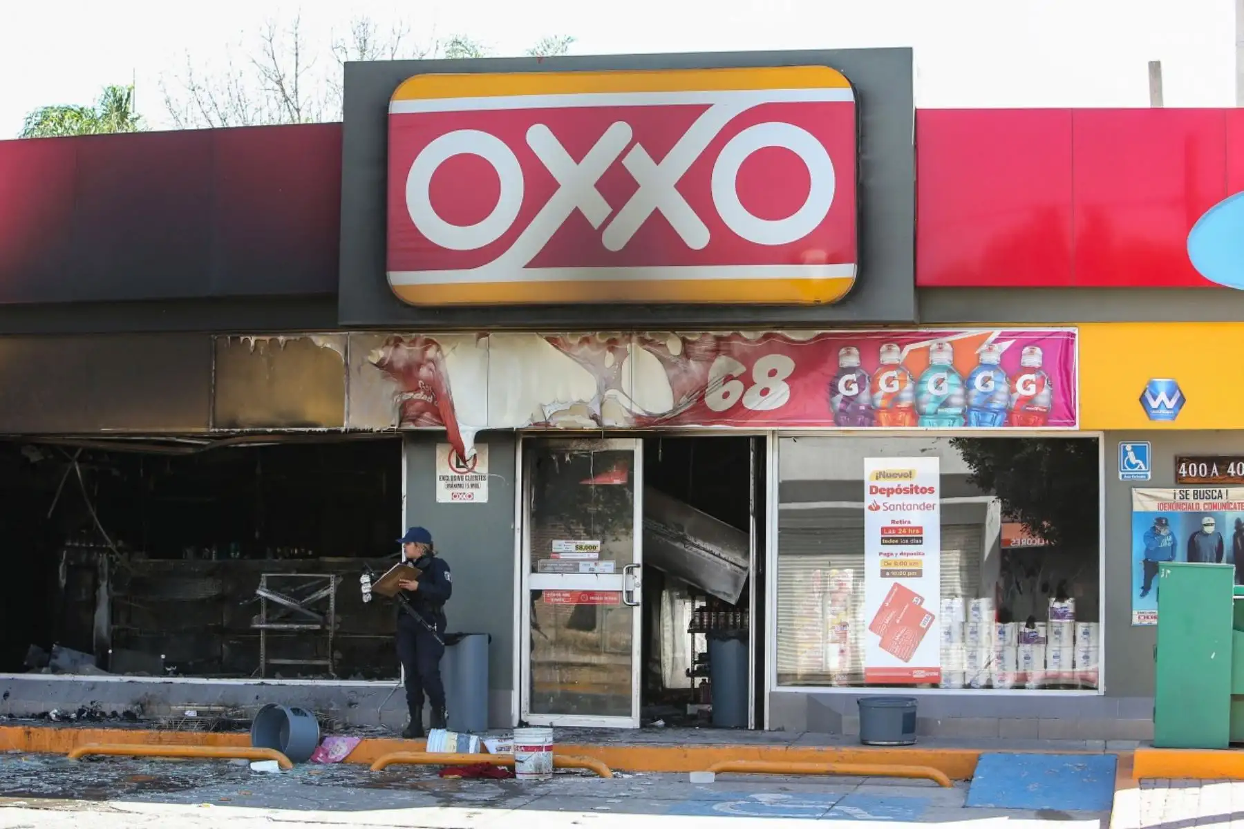 Un agente de la policía estatal mexicana inspecciona una tienda Oxxo presuntamente incendiada por miembros del crimen organizado durante enfrentamientos con fuerzas gubernamentales en San Francisco del Rincón, Guanajuato, México, el 22 de febrero de 2026. Foto: AFP