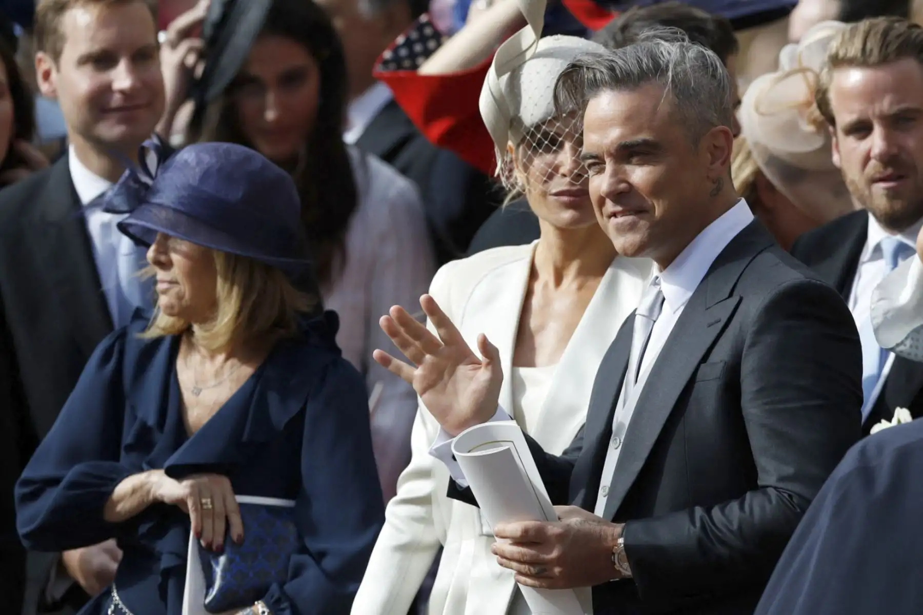 La cantante británica Robbie Williams (R) saluda a la multitud mientras se va después de asistir a la boda de la princesa Eugenie de York de Gran Bretaña con Jack Brooksbank en la Capilla de San Jorge, Castillo de Windsor, en Windsor, el 12 de octubre de 2018. Foto: AFP