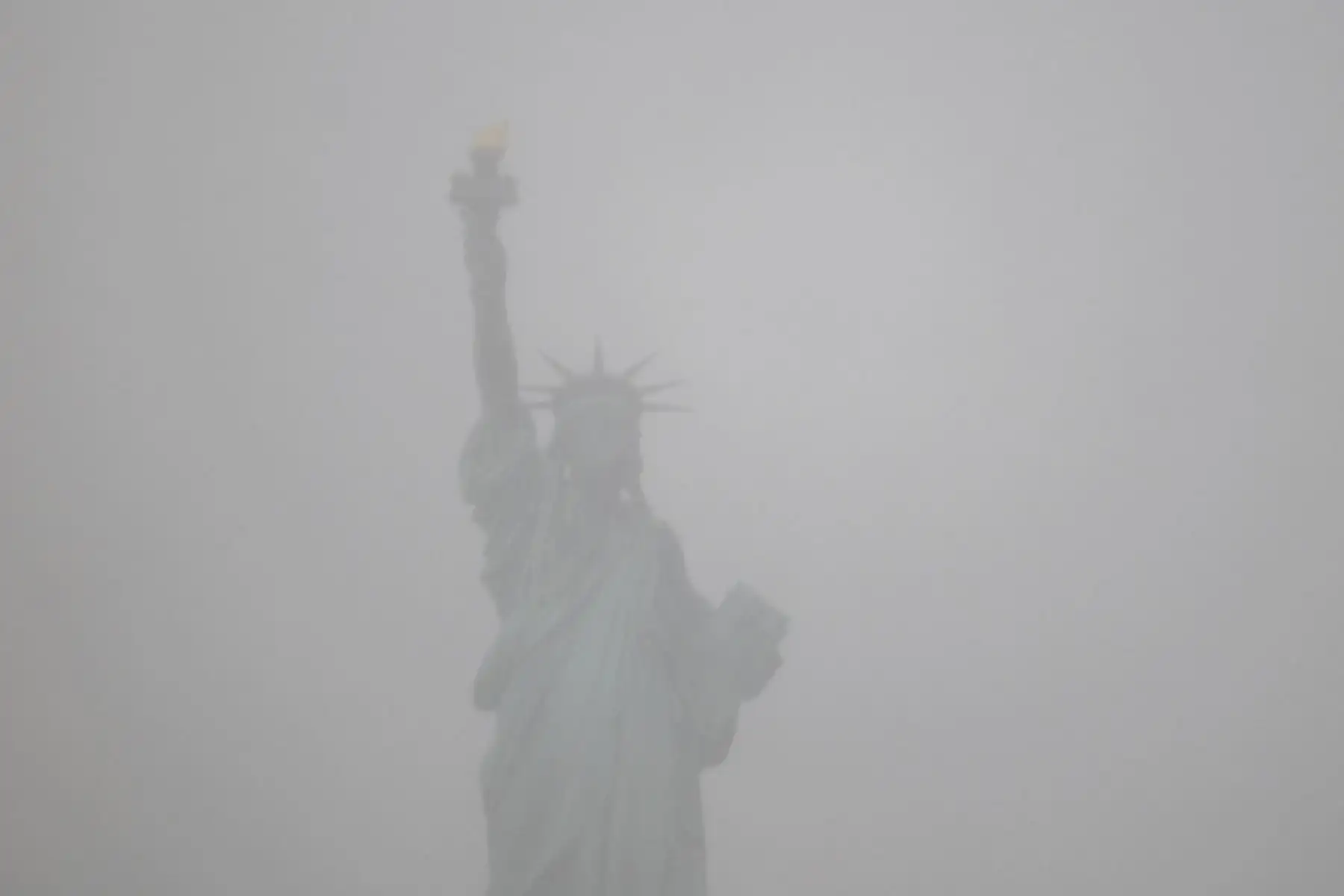 La Estatua de la Libertad se muestra parcialmente oscurecida cuando la nieve comienza a caer mientras la ciudad de Nueva York se prepara para un día extremadamente frío. Foto: AFP