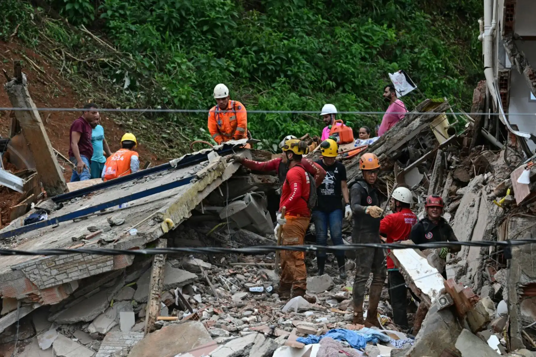 Equipos de rescate retiran escombros en busca de víctimas de un deslizamiento de tierra causado por las fuertes lluvias en el Barrio Parque Jardim Burnier, en Juiz de Fora, Minas Gerais, Brasil. Las lluvias torrenciales en el sureste de Brasil han dejado al menos 23 muertos y 47 desaparecidos en inundaciones y deslizamientos de tierra. Foto: ANDINA/AFP