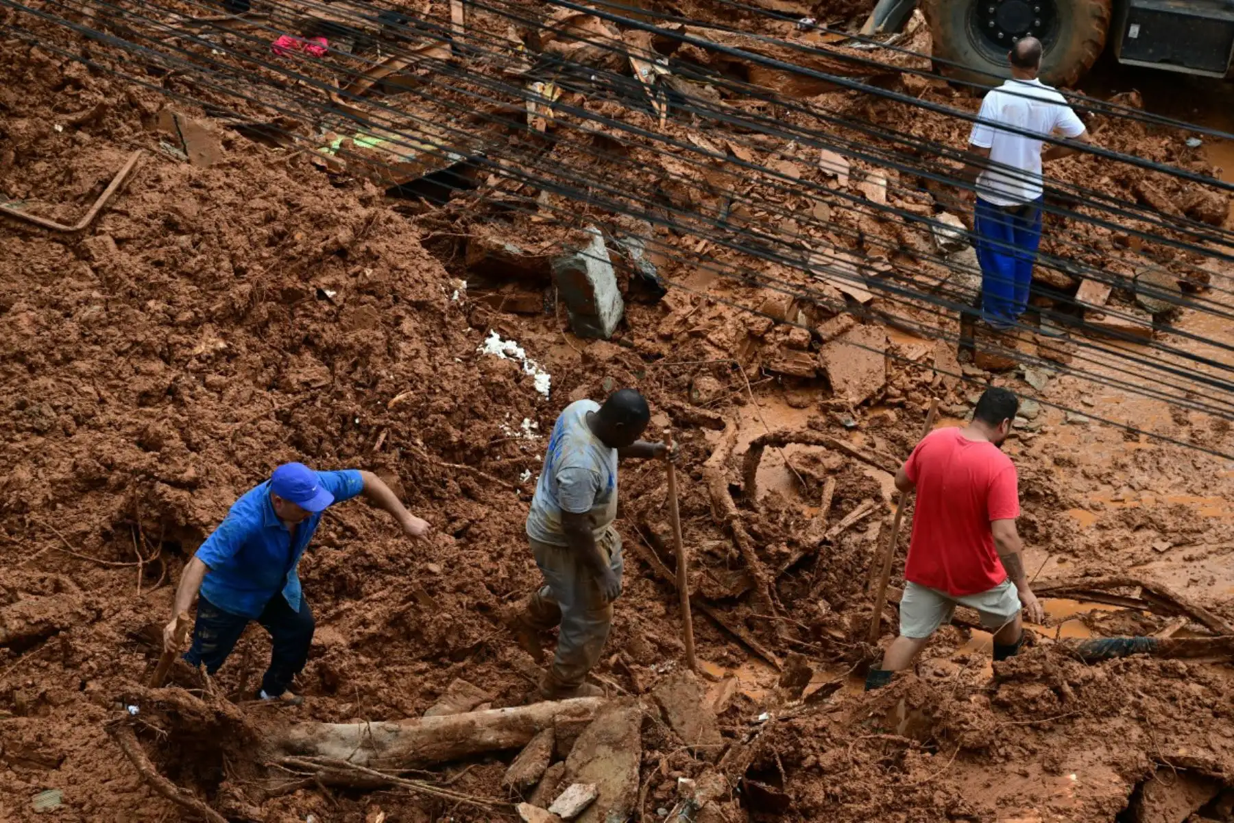 Equipos de rescate retiran escombros en busca de víctimas de un deslizamiento de tierra causado por las fuertes lluvias en el Barrio Parque Jardim Burnier, en Juiz de Fora, Minas Gerais, Brasil. Las lluvias torrenciales en el sureste de Brasil han dejado al menos 23 muertos y 47 desaparecidos en inundaciones y deslizamientos de tierra. Foto: ANDINA/AFP