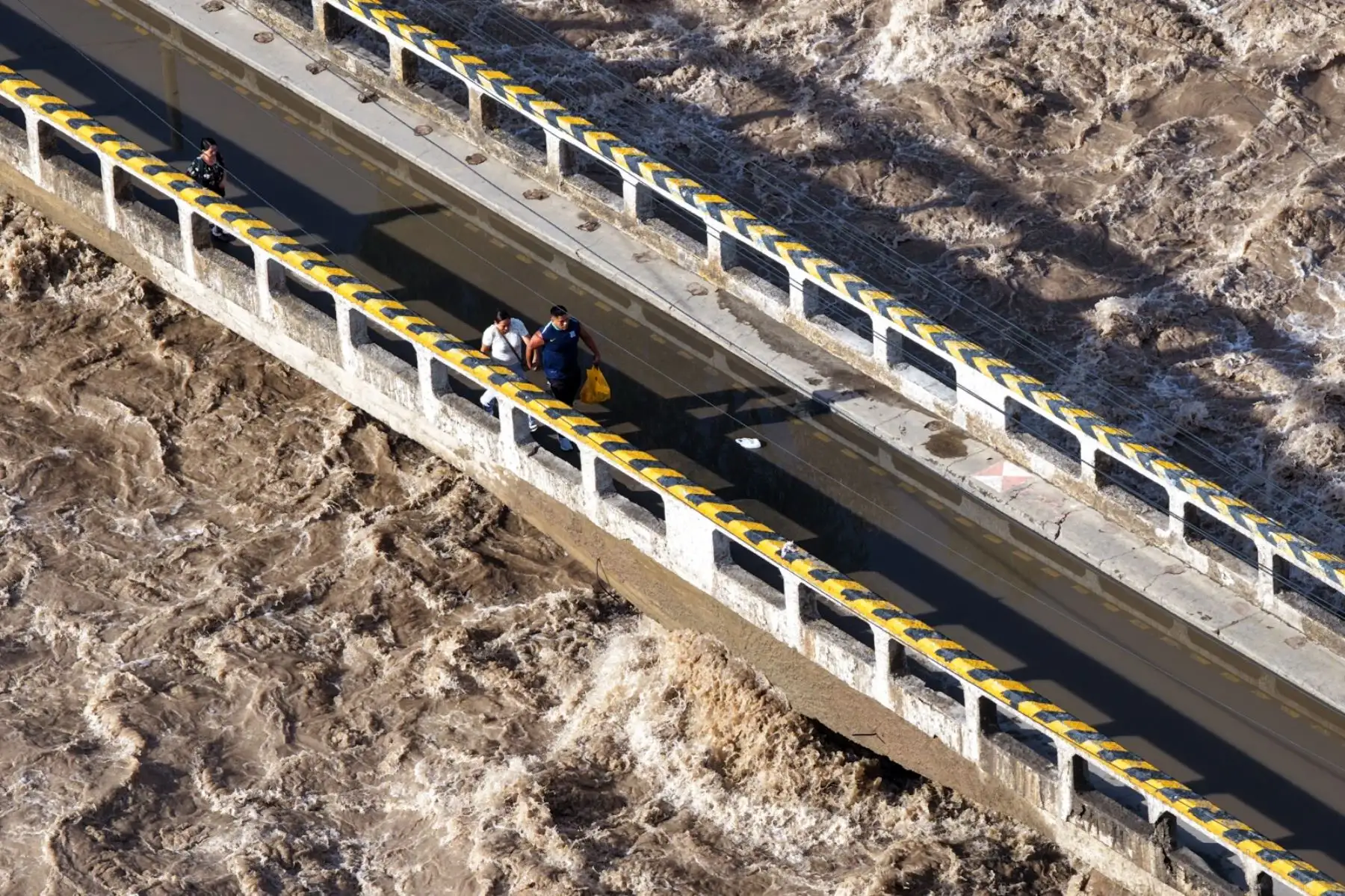 Pese a las restricciones y al riesgo evidente, varios vecinos continúan cruzando el puente “Caracol”, desobedeciendo las disposiciones de seguridad. Foto: ANDINA/ Ricardo Cuba