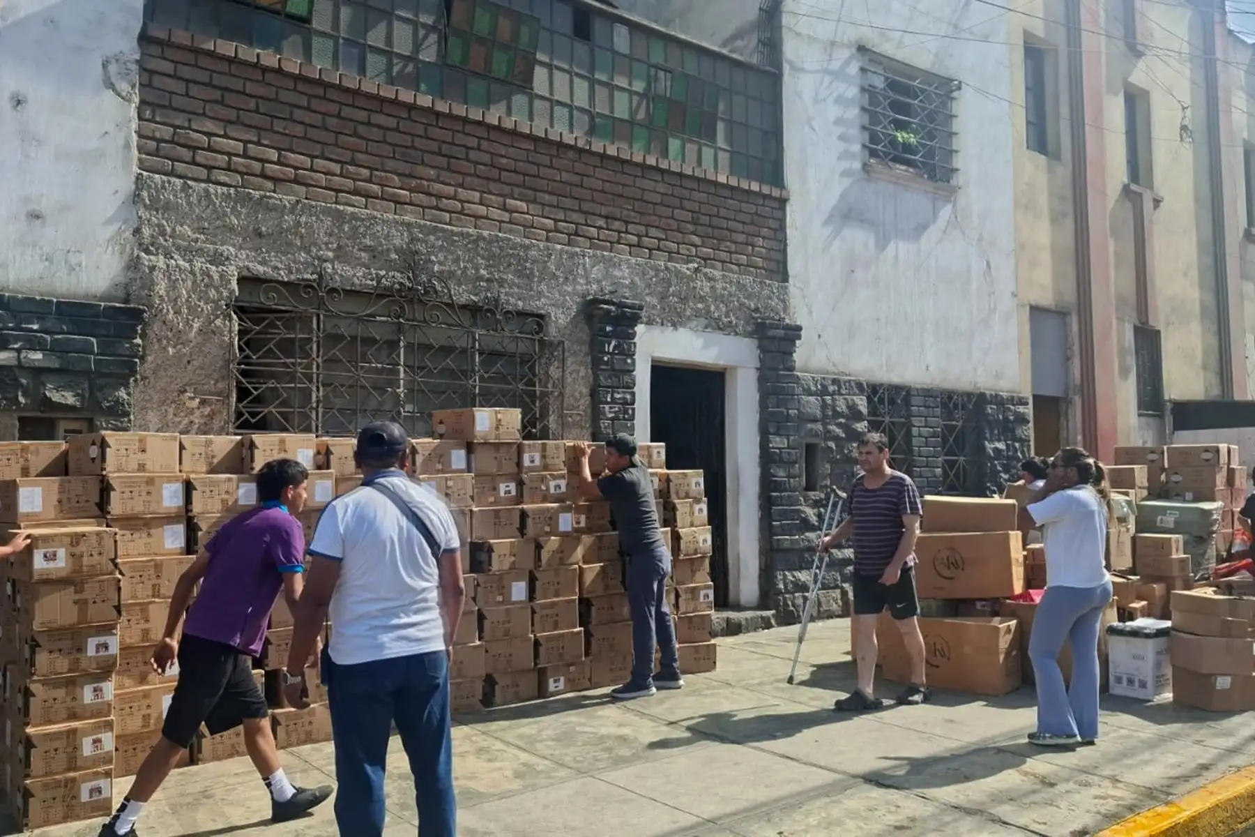 Comerciantes rescatan mercadería y la apilan en la vía pública, lejos de las llamas, ante el avance del fuego. Foto: ANDINA/ Héctor Vinces