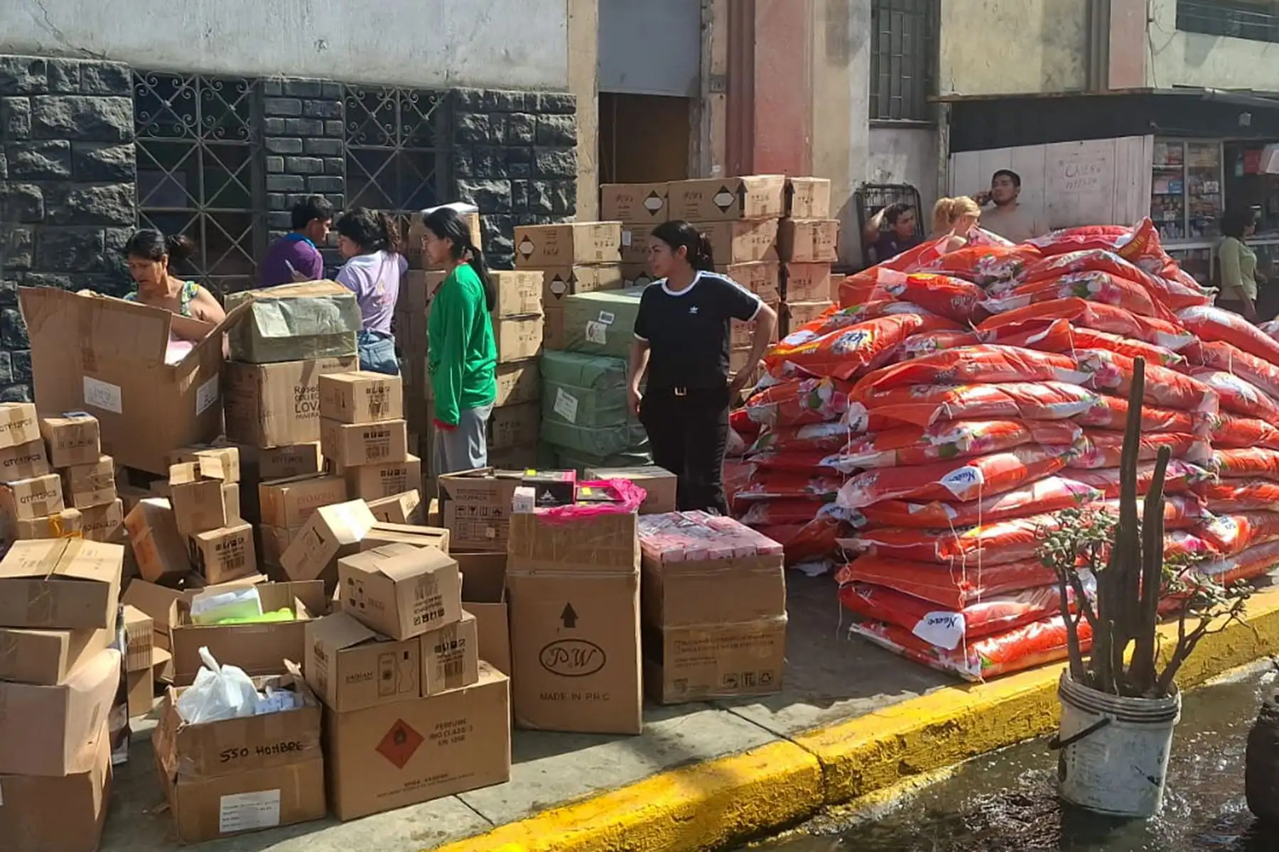 Comerciantes rescatan mercadería y la apilan en la vía pública, lejos de las llamas, ante el avance del fuego. Foto: ANDINA/ Héctor Vinces