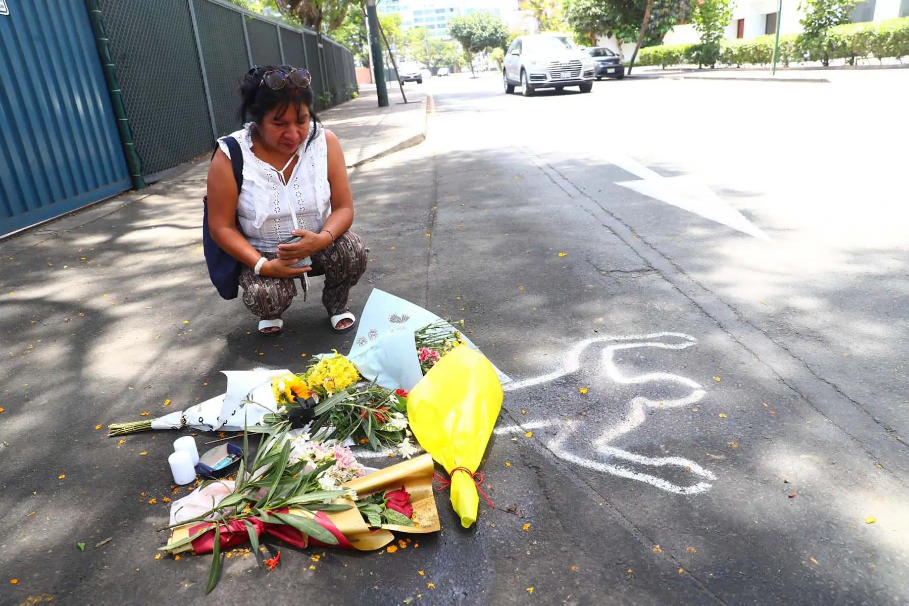 Una mujer se detiene frente a las flores colocadas sobre la pista, en un gesto de recogimiento ante la repentina pérdida de la atleta. Foto: ANDINA/ Verónica Calderón Zuñiga