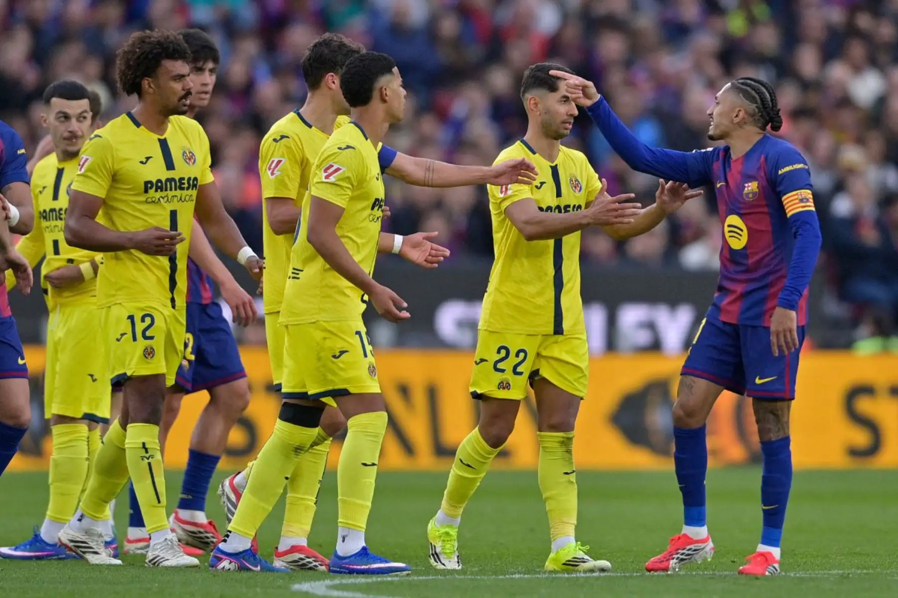 El delantero brasileño del Barcelona, ​​Raphinha, se enfrenta a los jugadores del Villarreal durante el partido de la liga española entre el FC Barcelona y el Villarreal CF.  Foto: ANDINA/AFP