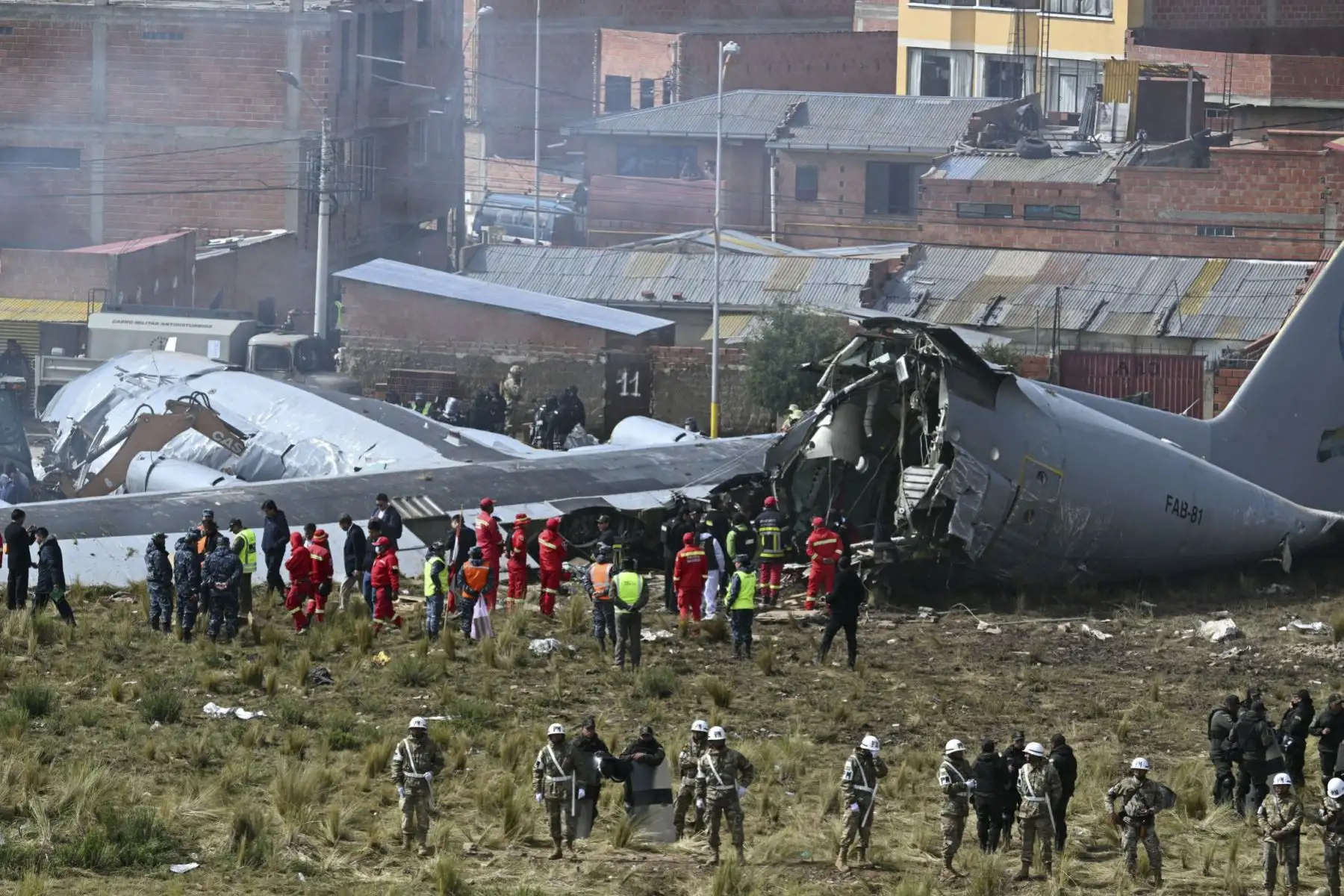 Equipos de rescate, personal militar y oficiales forenses trabajan en el lugar del accidente del avión Lockheed C-130 de la Fuerza Aérea Boliviana (FAB-81) en El Alto, cerca de La Paz, el 28 de febrero de 2026. Al menos 20 personas murieron el 27 de febrero en un accidente aéreo militar en Bolivia que transportaba efectivo y se estrellaron mientras aterrizaba en el aeropuerto de El Alto, cerca de La Paz, informaron las autoridades. (Foto de AIZAR RALDES / AFP)