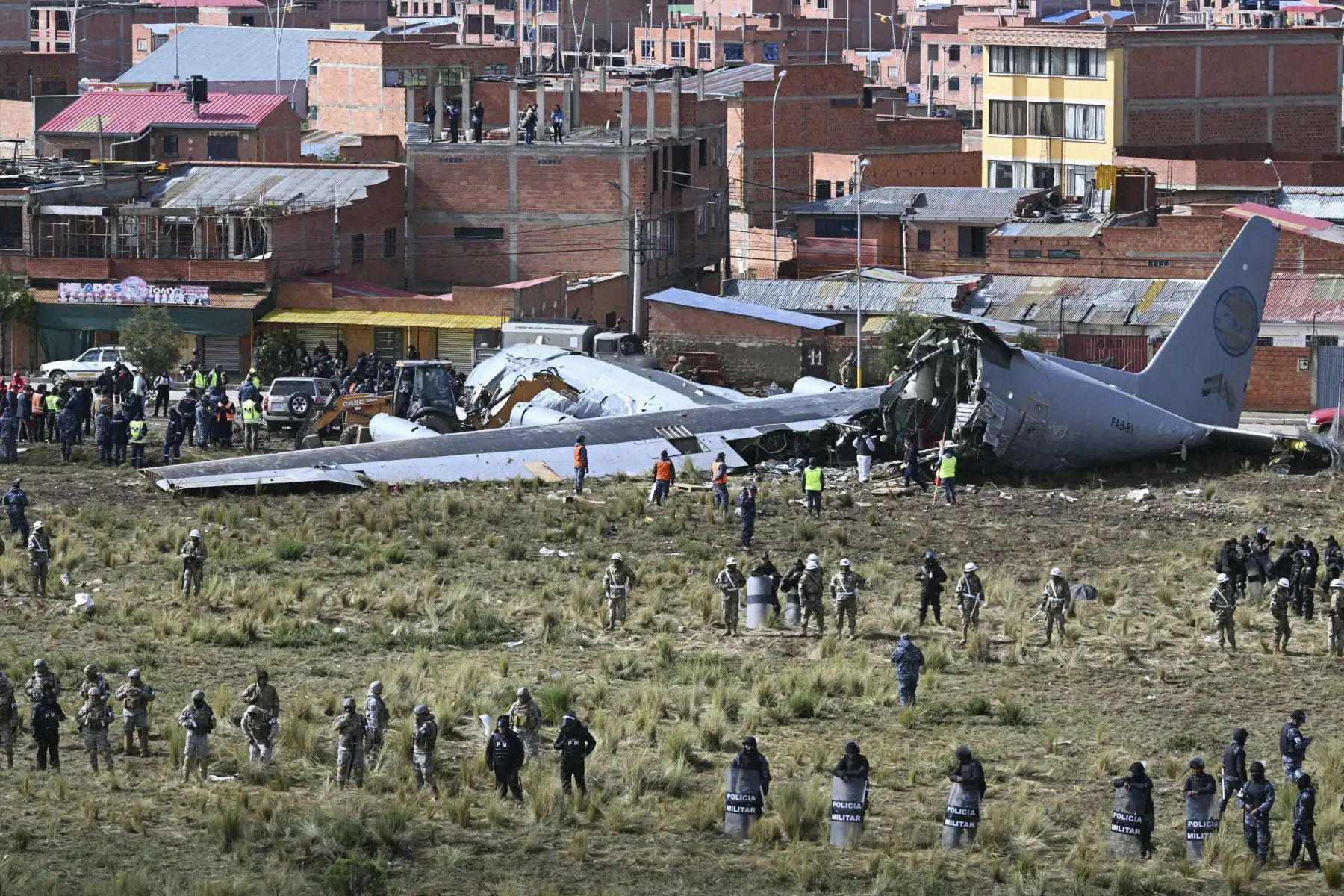 Equipos de rescate, personal militar y oficiales forenses trabajan en el lugar del accidente del avión Lockheed C-130 de la Fuerza Aérea Boliviana (FAB-81) en El Alto, cerca de La Paz, el 28 de febrero de 2026. Al menos 20 personas murieron el 27 de febrero en un accidente aéreo militar en Bolivia que transportaba efectivo y se estrellaron mientras aterrizaba en el aeropuerto de El Alto, cerca de La Paz, informaron las autoridades. (Foto de AIZAR RALDES / AFP)