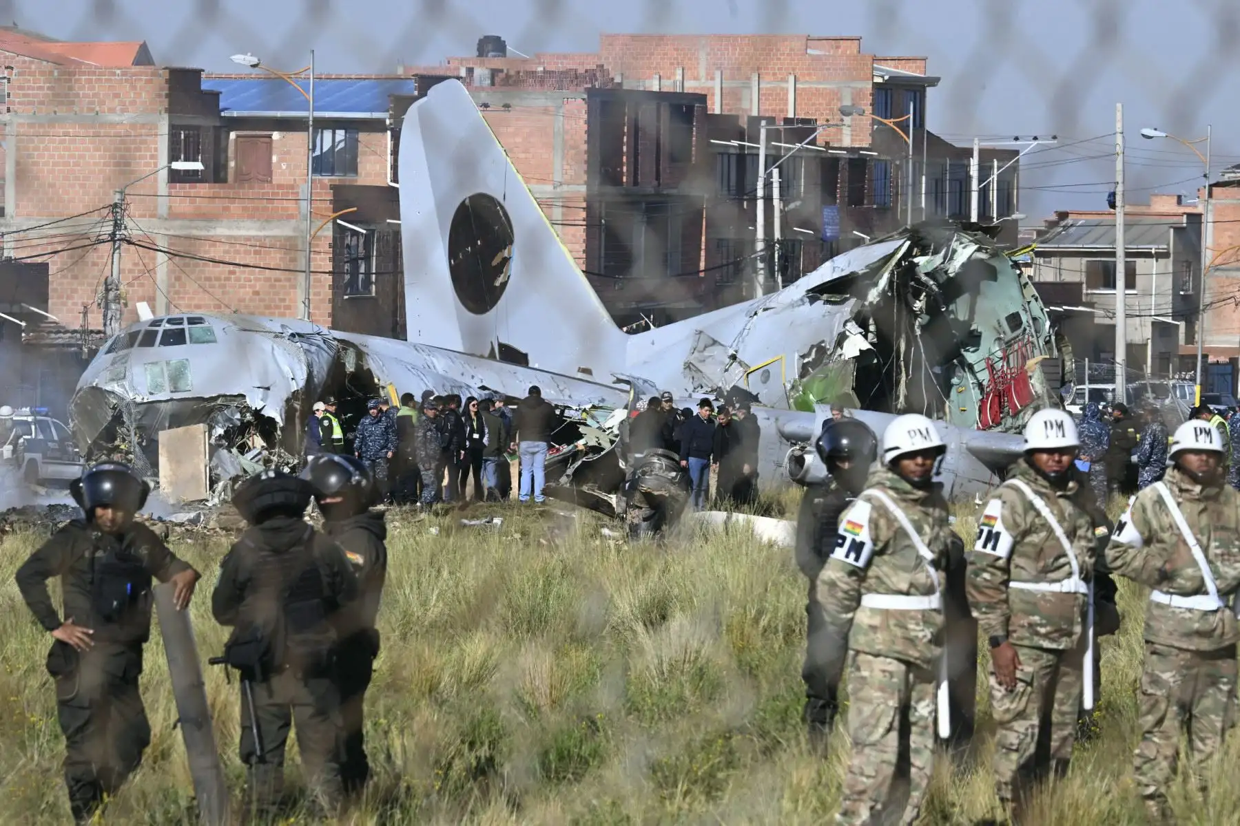 Equipos de rescate, personal militar y oficiales forenses trabajan en el lugar del accidente del avión Lockheed C-130 de la Fuerza Aérea Boliviana (FAB-81) en El Alto, cerca de La Paz, el 28 de febrero de 2026. Al menos 20 personas murieron el 27 de febrero en un accidente aéreo militar en Bolivia que transportaba efectivo y se estrellaron mientras aterrizaba en el aeropuerto de El Alto, cerca de La Paz, informaron las autoridades. (Foto de AIZAR RALDES / AFP)
