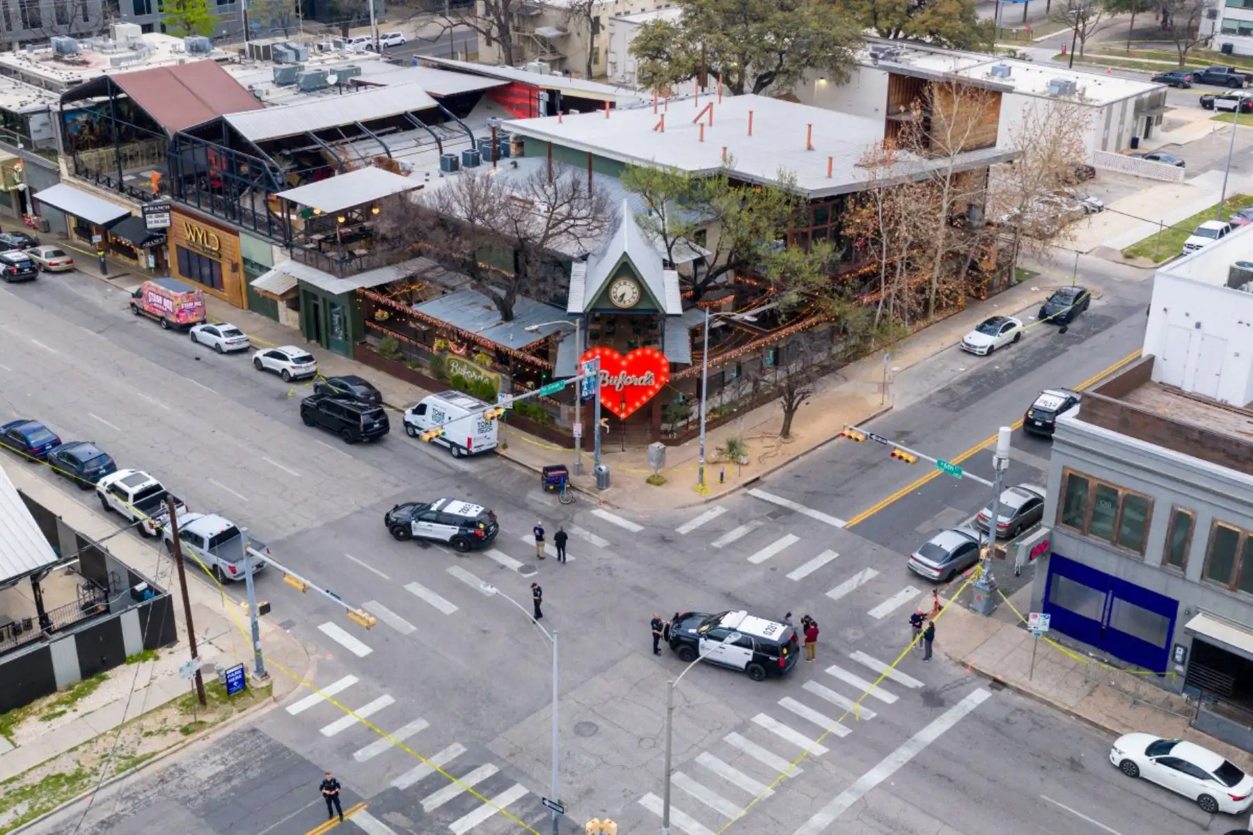 En una vista aérea, miembros del FBI y las fuerzas del orden locales patrullan y realizan una investigación tras un tiroteo masivo frente al bar Buford