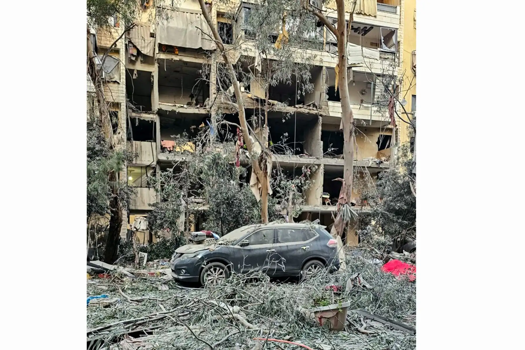 Personas revisan los restos de los vehículos dañados en un ataque aéreo israelí en Haret Hreik, un suburbio al sur de Beirut. Foto: AFP