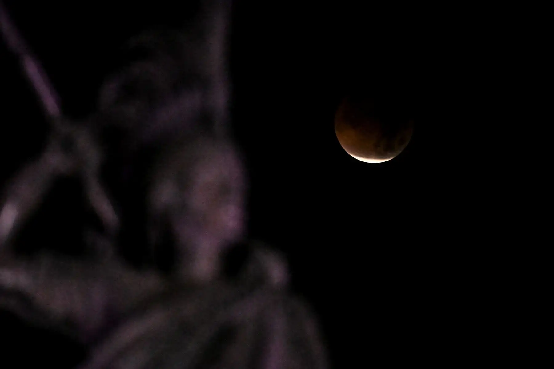 La luna se ve durante un eclipse lunar total o "Luna de Sangre" al fondo del Monumento a Cuauhtémoc, el último gobernante indígena mexica de Tenochtitlan, en la Ciudad de México. Foto: AFP