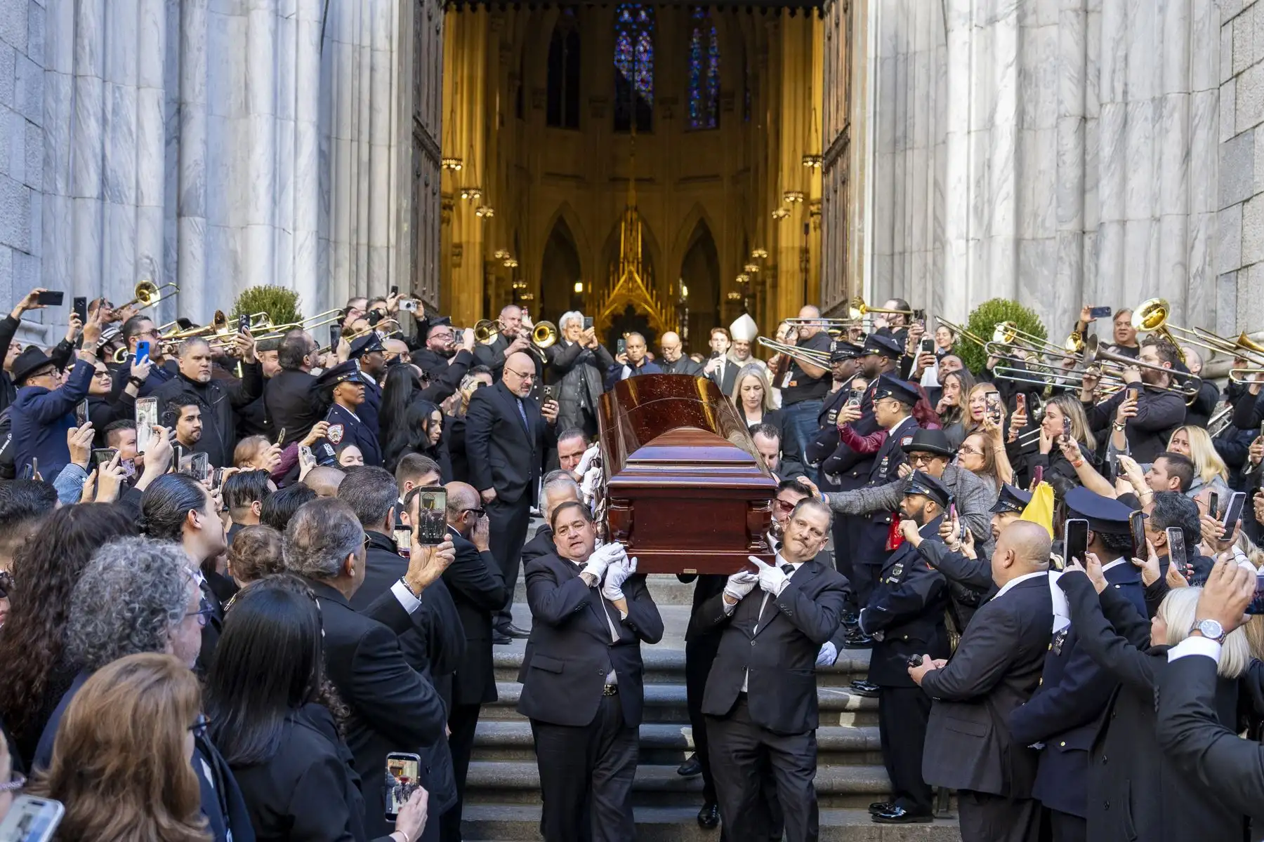 Personas sostienen el féretro del cantante Willie Colón este lunes, al finalizar una misa pública en la Catedral de San Patricio en Nueva York  Foto: EFE