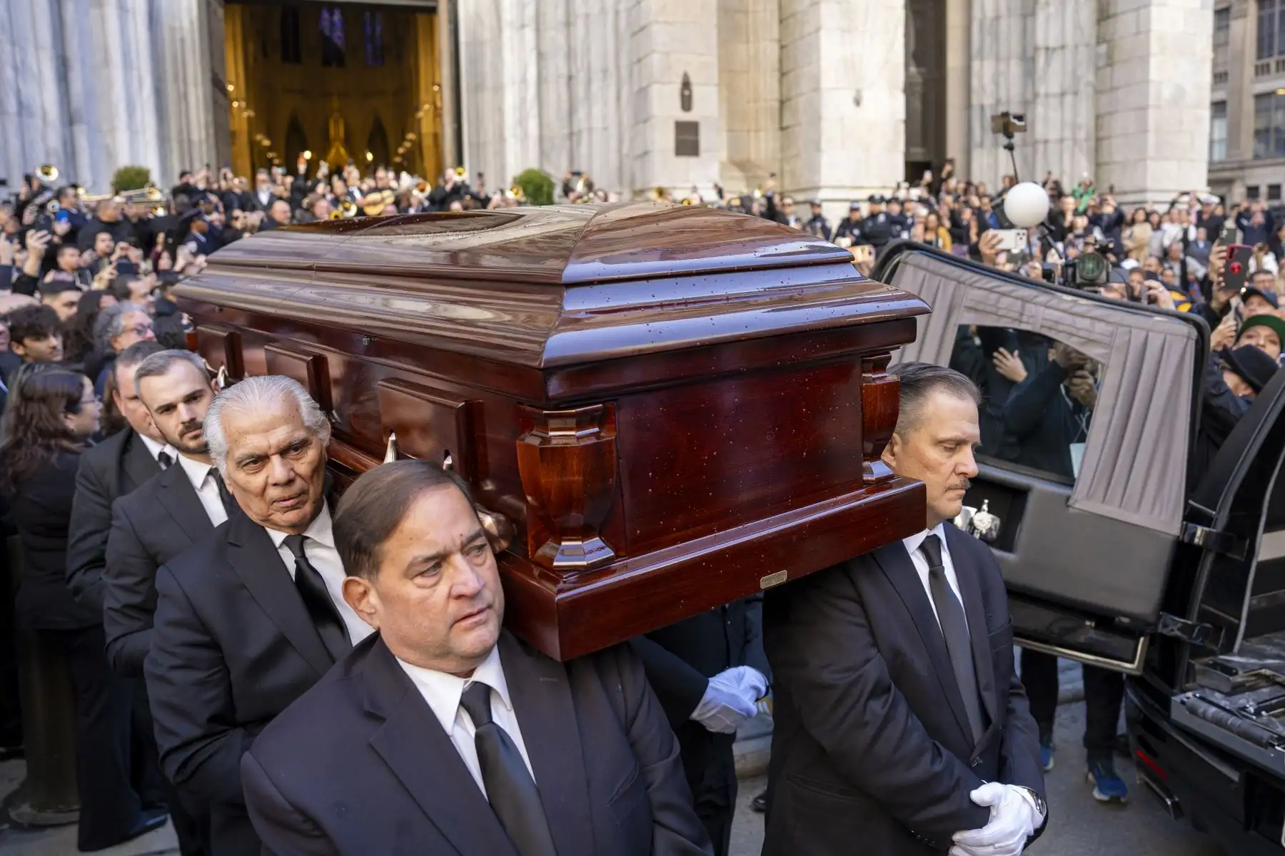 Personas sostienen el féretro del cantante Willie Colón este lunes, al finalizar una misa pública en la Catedral de San Patricio en Nueva York  Foto: EFE