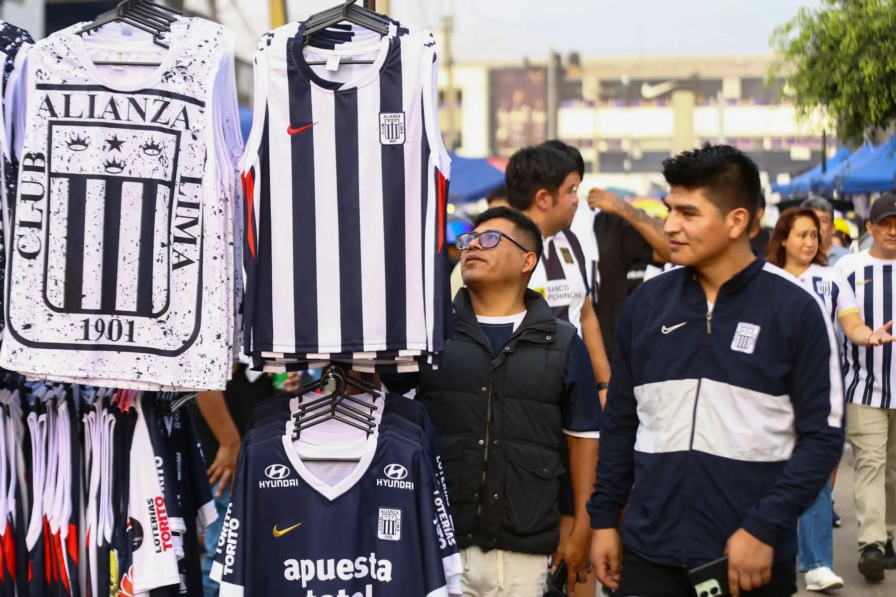 Hinchas de Alianza Lima llegaron al Estadio Alejandro Villanueva, en Matute, para alentar a su equipo antes del partido frente a FBC Melgar por el Torneo Apertura de la Liga 1 2026. En los exteriores del recinto se vivió un ambiente festivo, con aficionados que lucieron camisetas blanquiazules, banderas y cánticos, mientras aguardaban el inicio del encuentro programado para la noche en el recinto victoriano. Foto: ANDINA/Ricardo Cuba