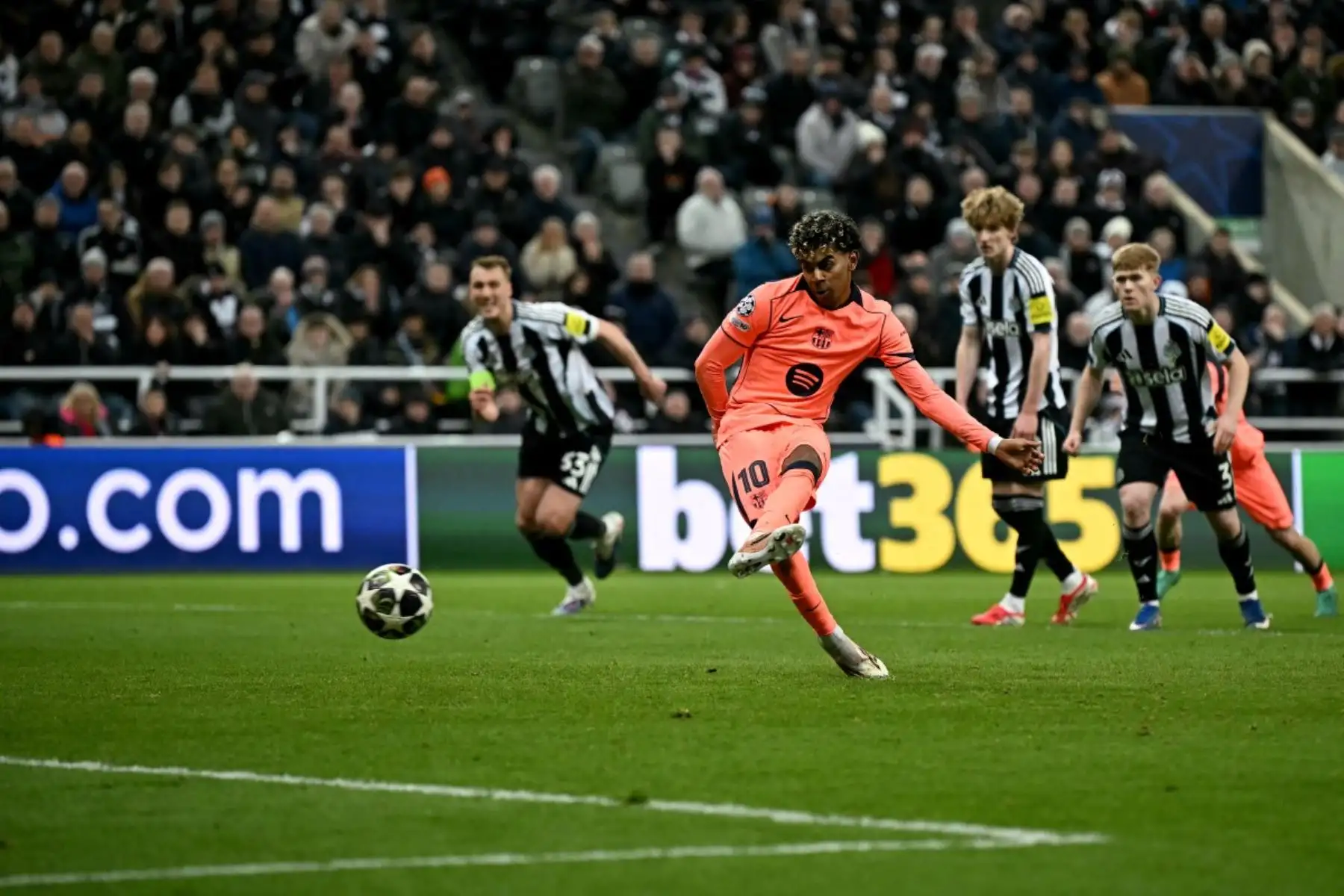 El delantero español  del Barcelona, ​​Lamine Yamal, dispara desde el punto de penalti para marcar el primer gol del equipo durante el partido de octavos de final de la UEFA Champions League entre el Newcastle United y el FC Barcelona. AFP