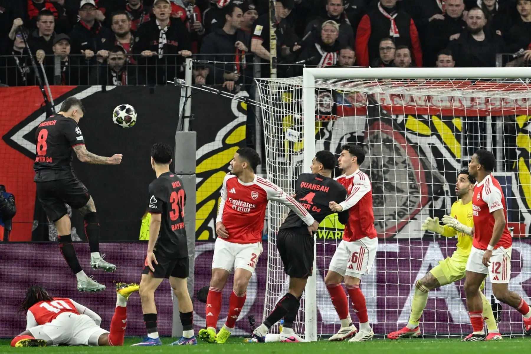El centrocampista alemán del Bayer Leverkusen  Robert Andrich  cabecea el balón para marcar el primer gol que supera al portero español del Arsenal  David Raya durante el partido de ida de los octavos de final de la UEFA Champions League Bayer 04 Leverkusen vs Arsenal. AFP