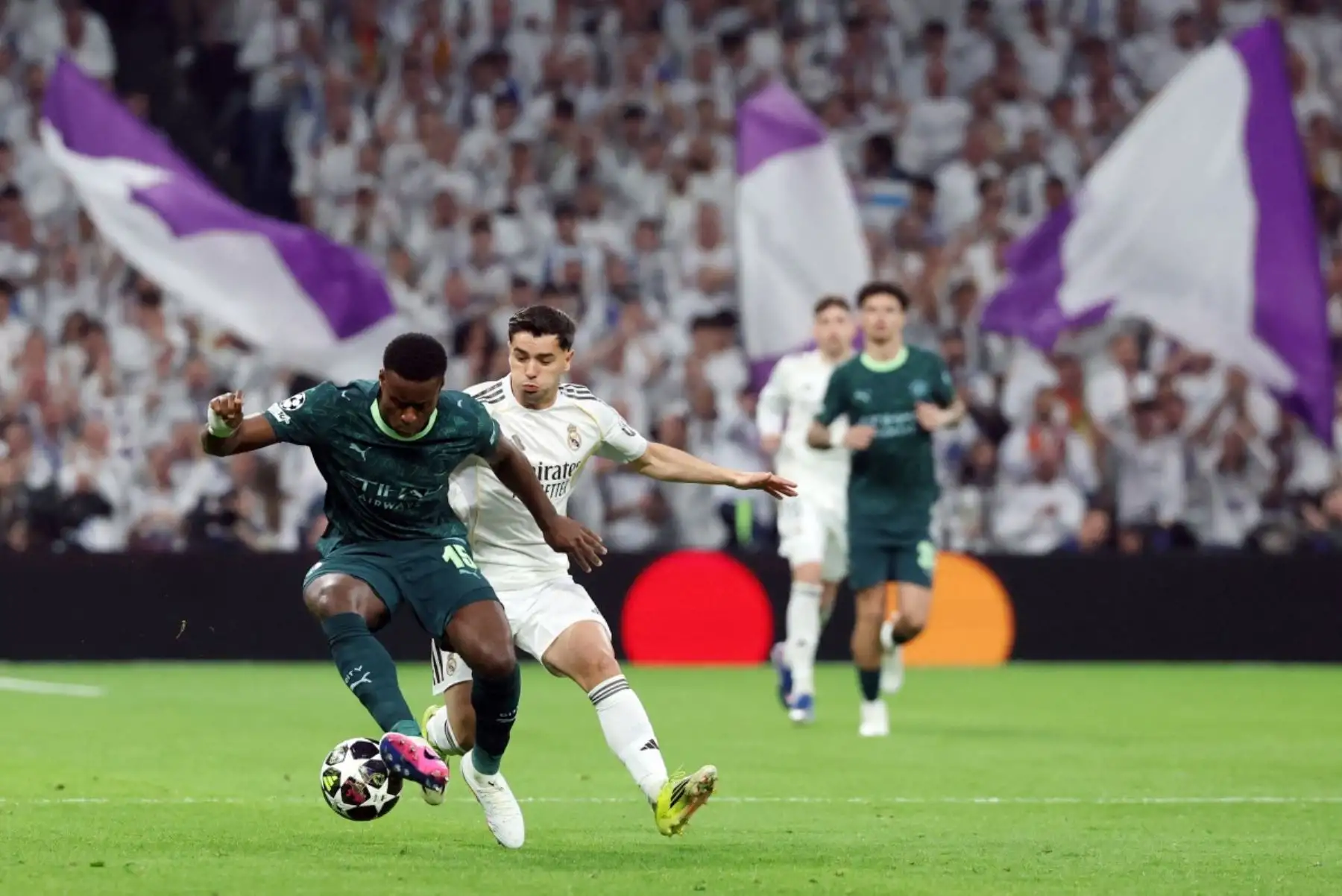 El defensa inglés  del Manchester City Marc Guehi  y el delantero marroquí  del Real Madrid Brahim Díaz luchan por el balón durante el partido de ida de los octavos de final de la UEFA Champions League entre el Real Madrid CF y el Manchester City. AFP