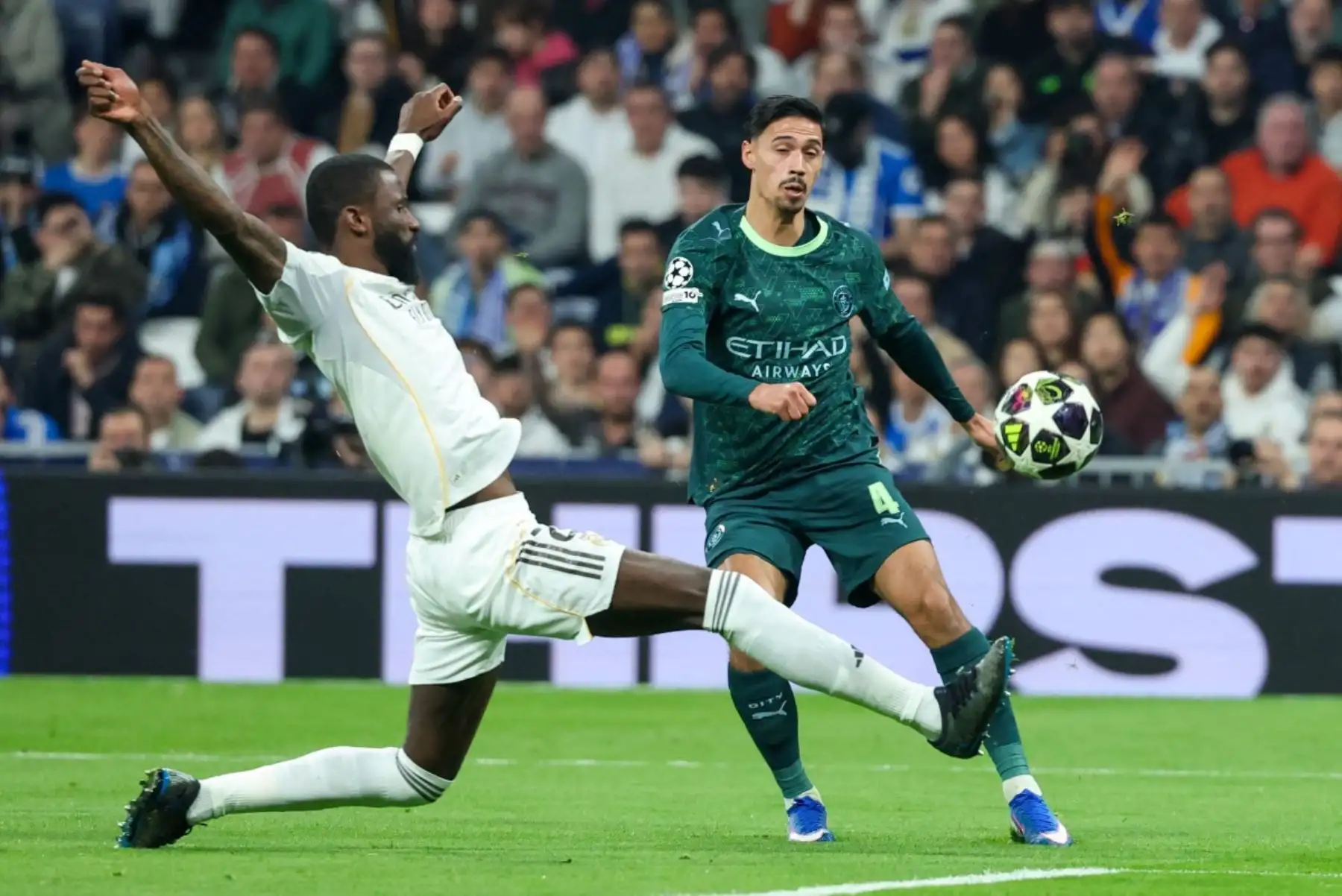 El defensa alemán  del Real Madrid, Antonio Ruediger, compite por el balón con el centrocampista holandés  del Manchester City, Tijjani Reijnders, durante el partido de ida de los octavos de final de la UEFA Champions League entre el Real Madrid CF y el Manchester City. AFP