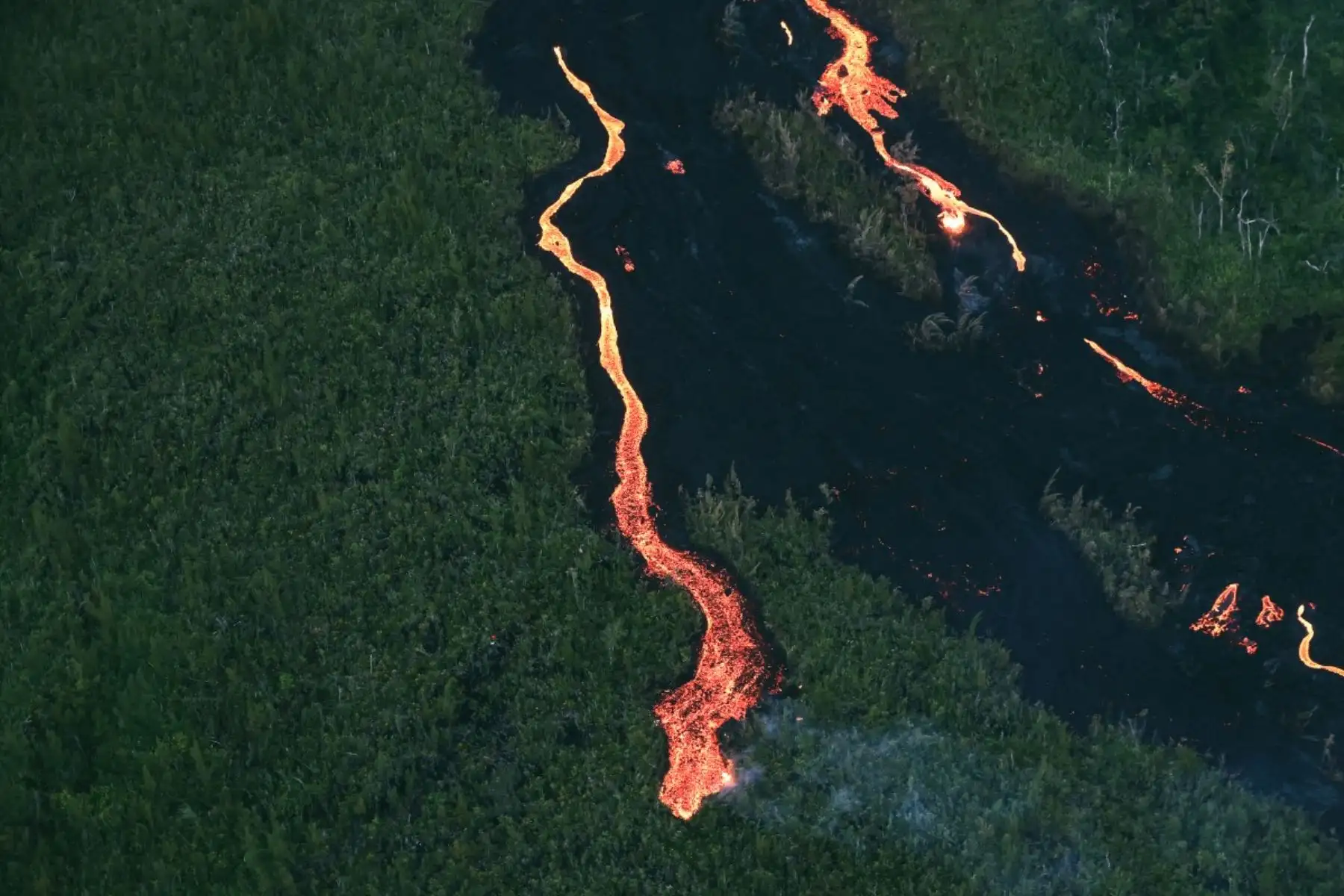 Flujo de lava abriéndose paso a través de una zona boscosa y cruzando la carretera RN2 cerca de Sainte-Rose, próxima al volcán Piton de la Fournaise, en el sureste de la isla francesa de La Reunión. Foto: AFP